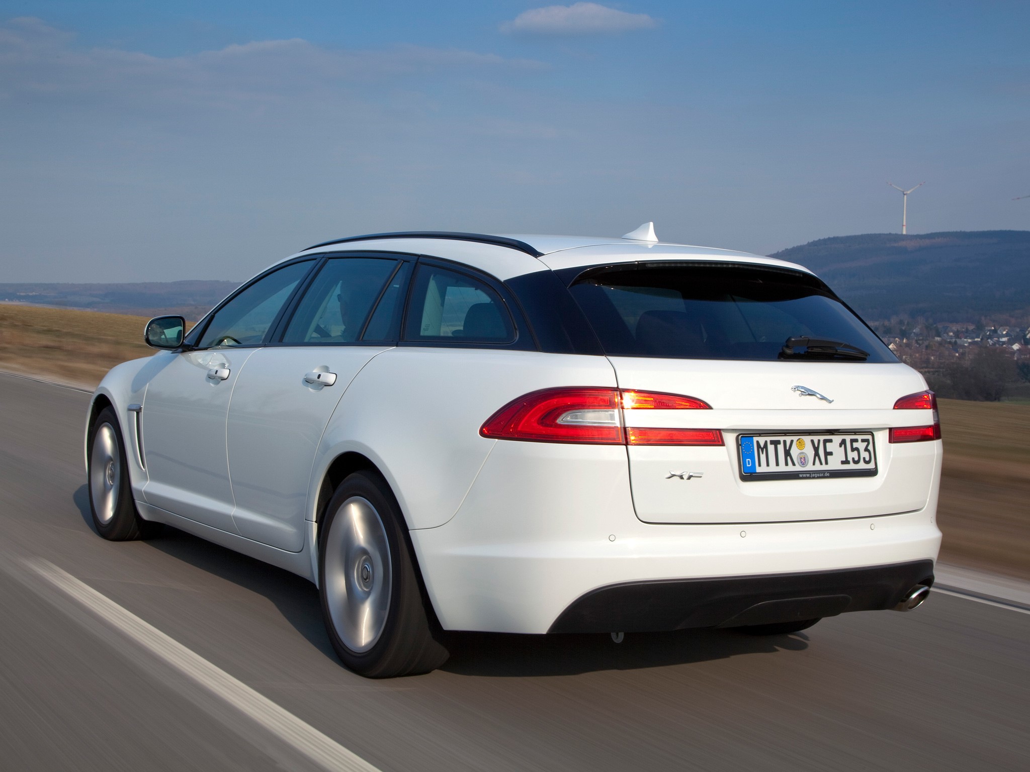 White Jaguar XF Sportbrake driving on a road HD Wallpaper