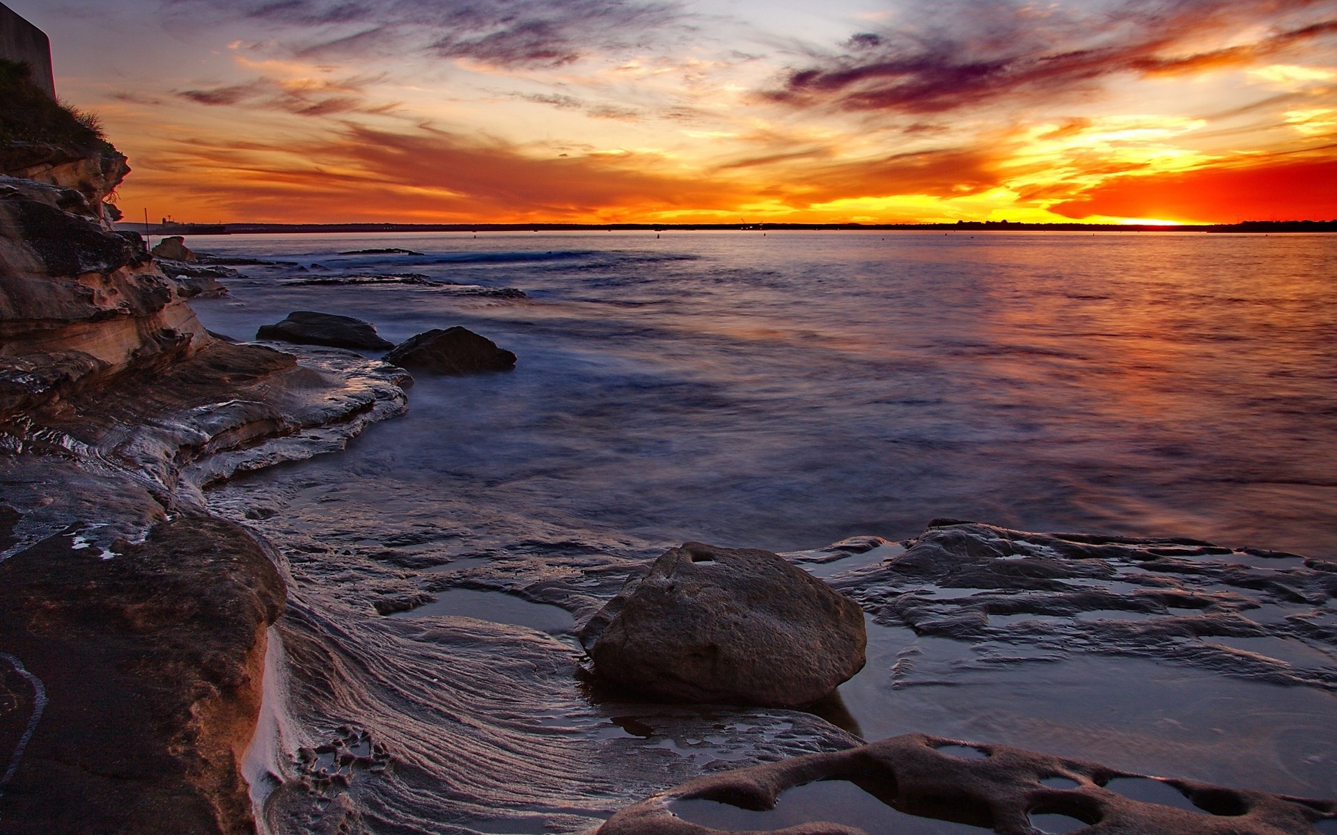 Sunset over rocky coastline with ocean waves HD Wallpaper
