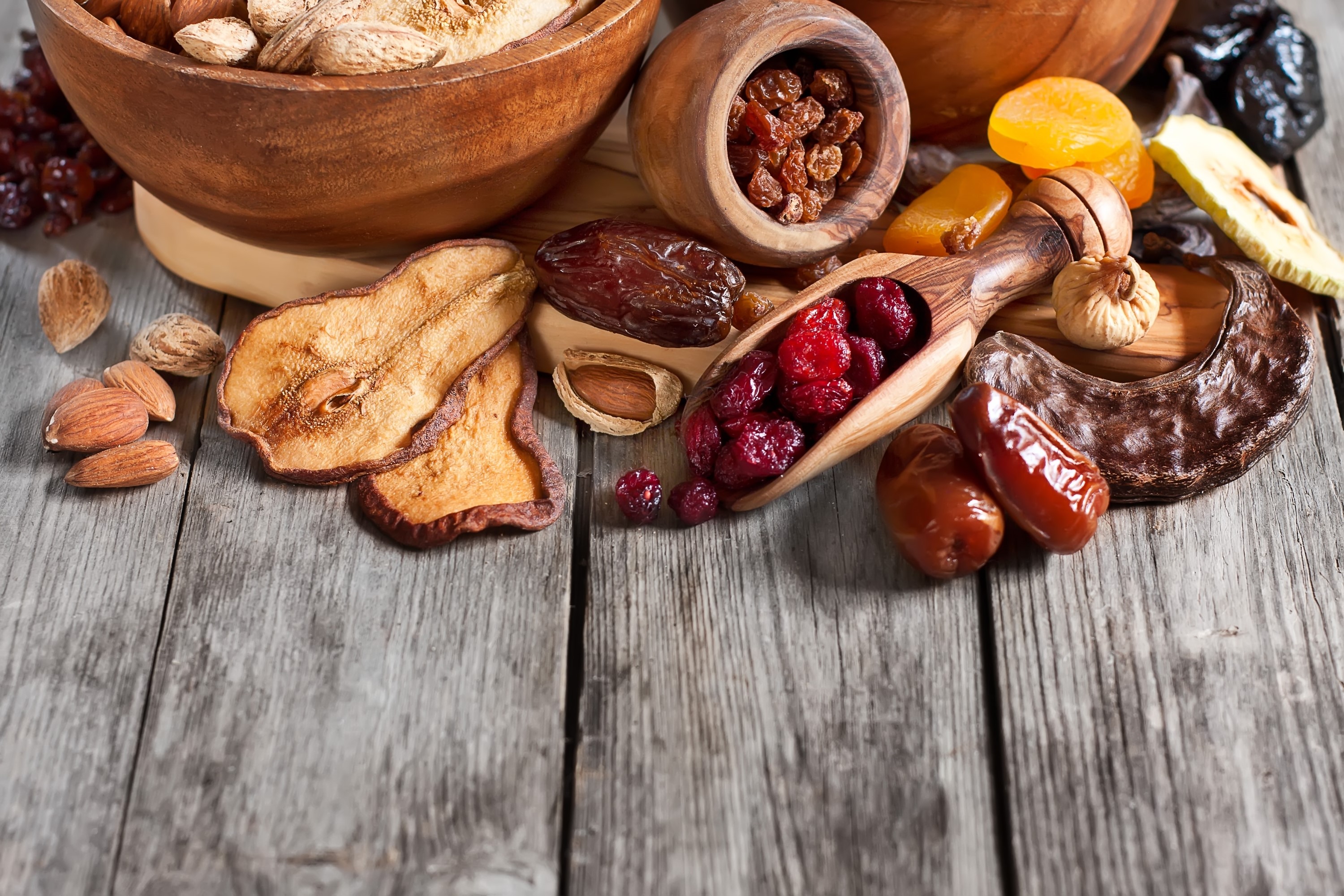 Assortment of dried fruits and nuts on wooden planks HD Wallpaper