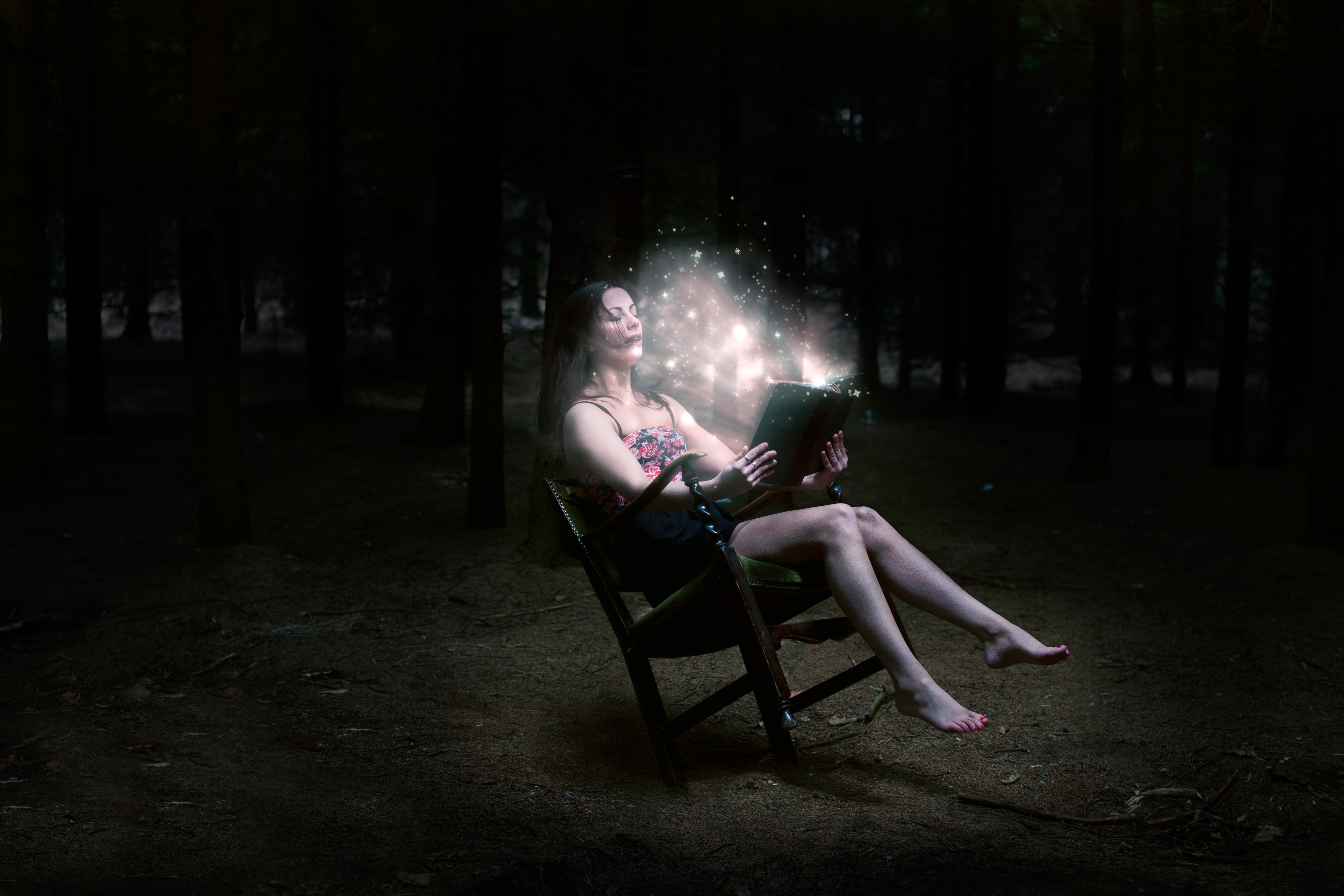 Woman reading a magical book in a dark forest HD Wallpaper