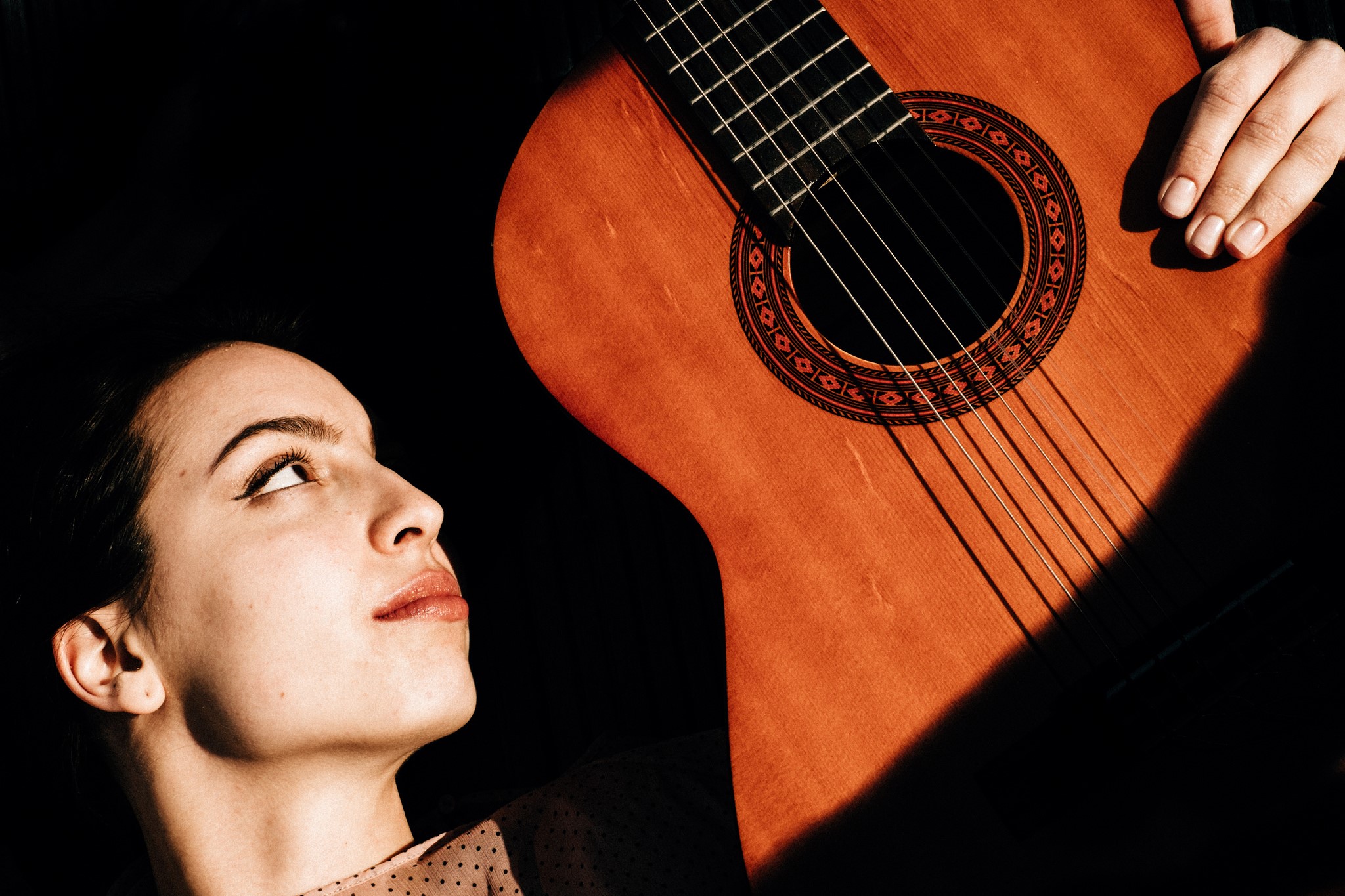 Woman looking up at a guitar HD Wallpaper