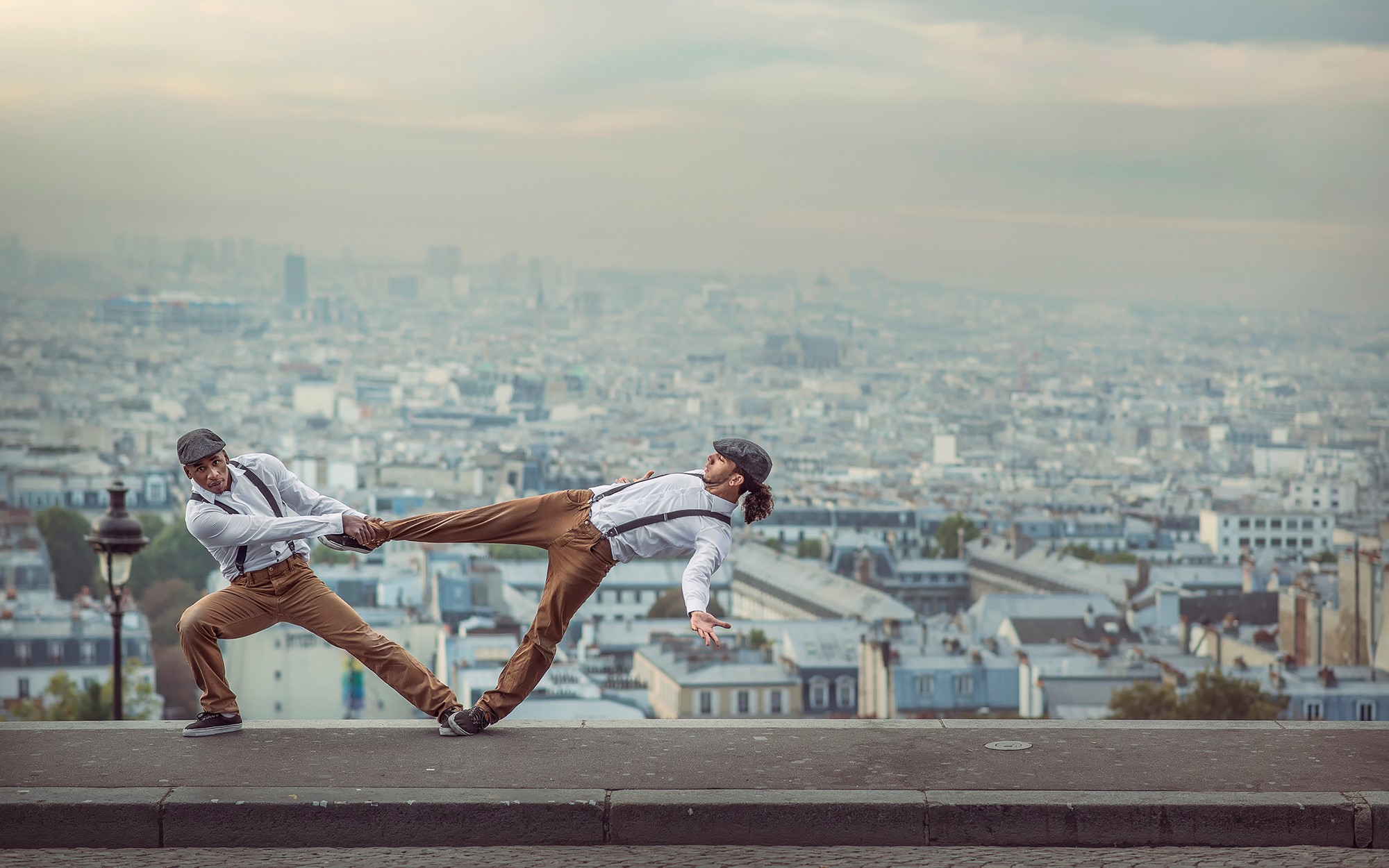 Two men dancing on a ledge in Paris HD Wallpaper