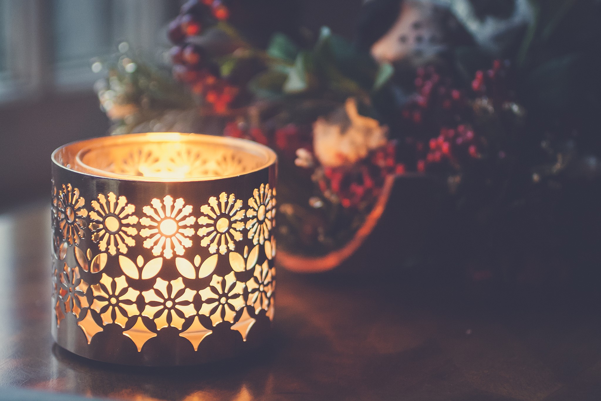 Lit candle in a decorative lantern with berries HD Wallpaper