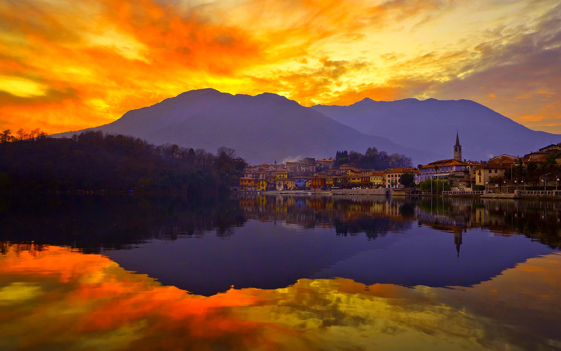 Sunset over a lake with mountains and a town HD Wallpaper