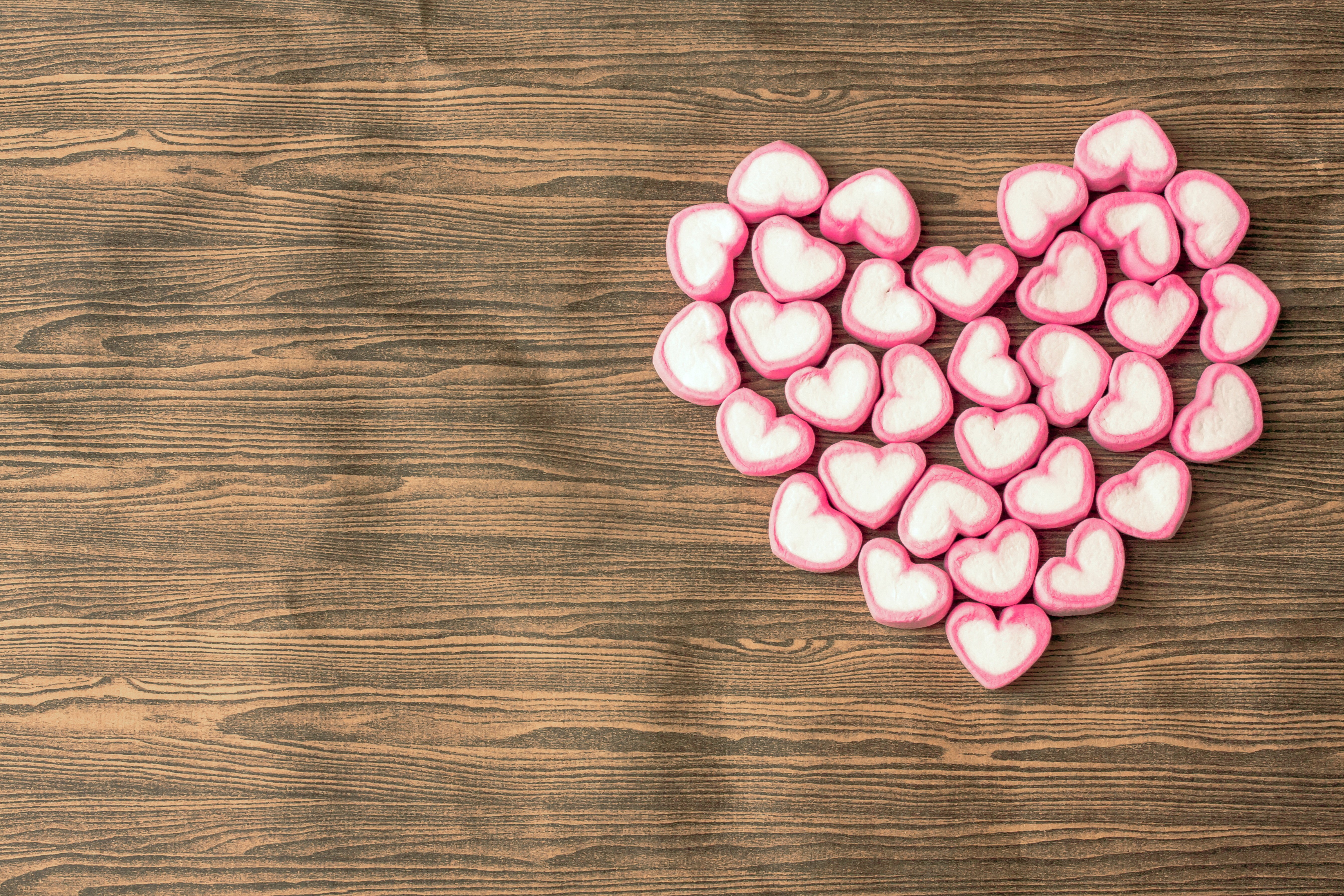 Heart shape made of pink and white marshmallows on a wooden background HD Wallpaper
