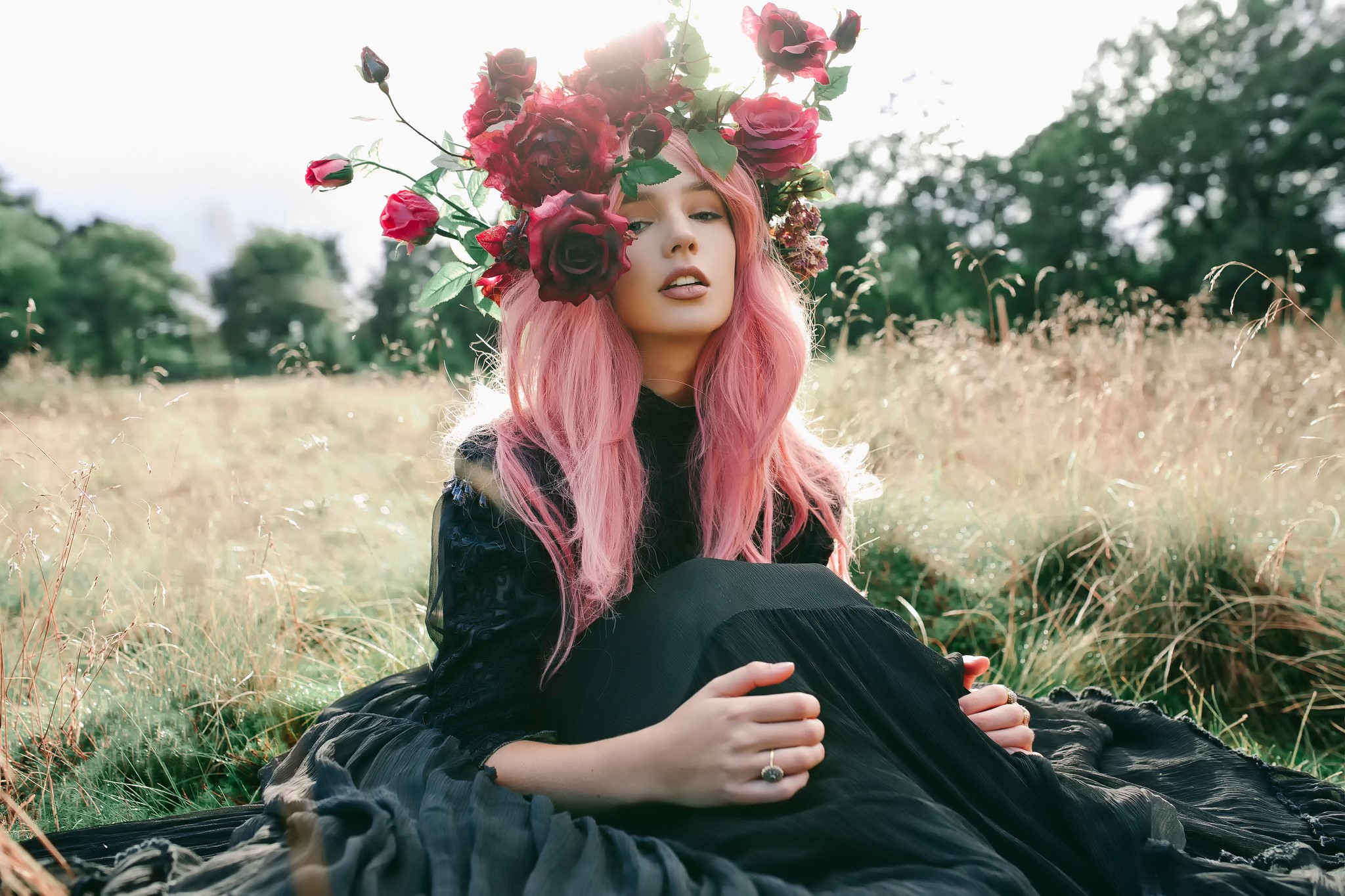 Woman with pink hair and flower crown sitting in a field HD Wallpaper