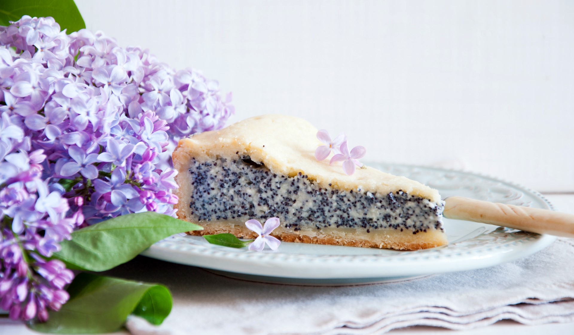 Slice of poppy seed pie with lilac flowers HD Wallpaper