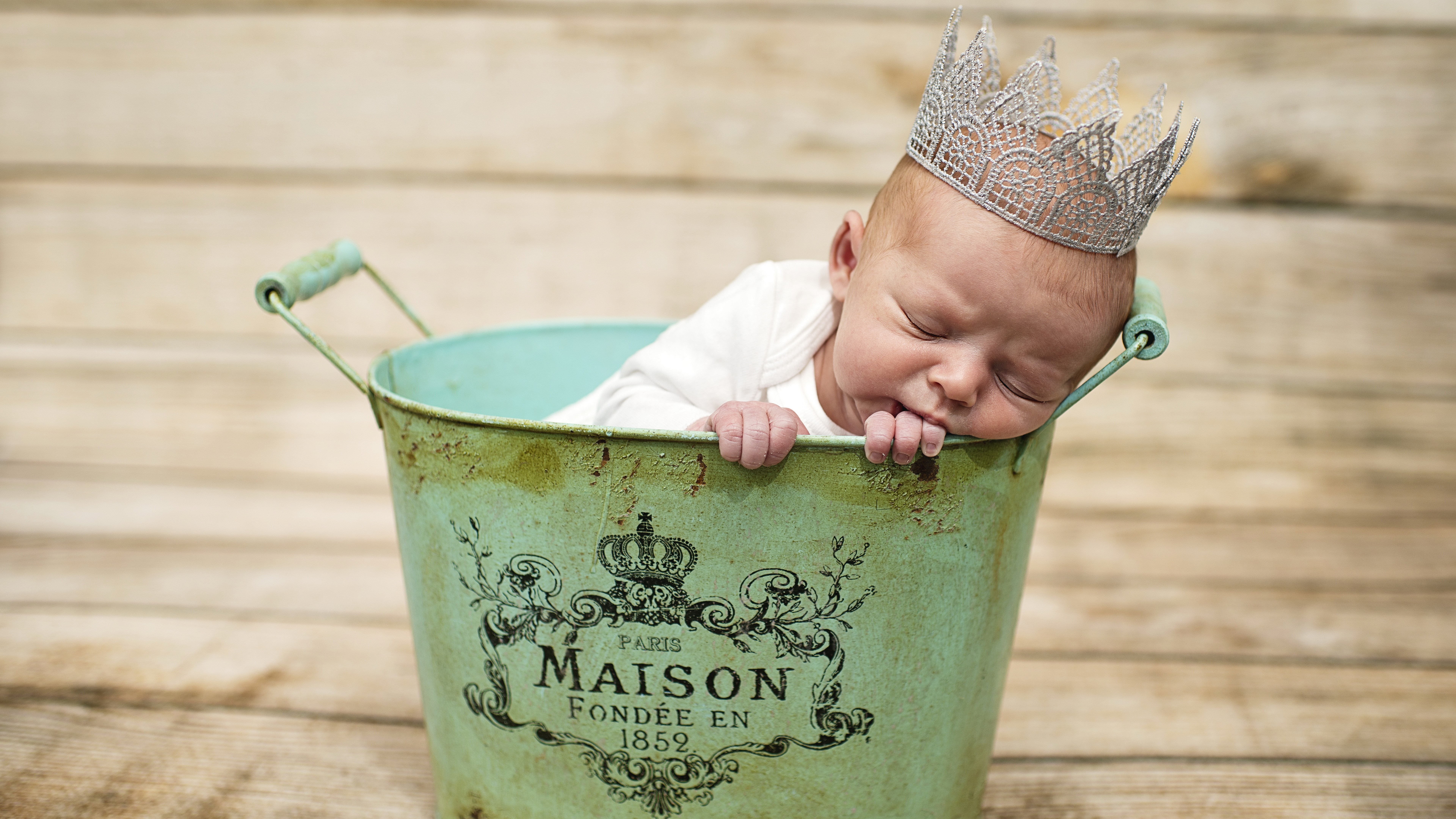 Baby wearing a crown sleeping in a bucket HD Wallpaper