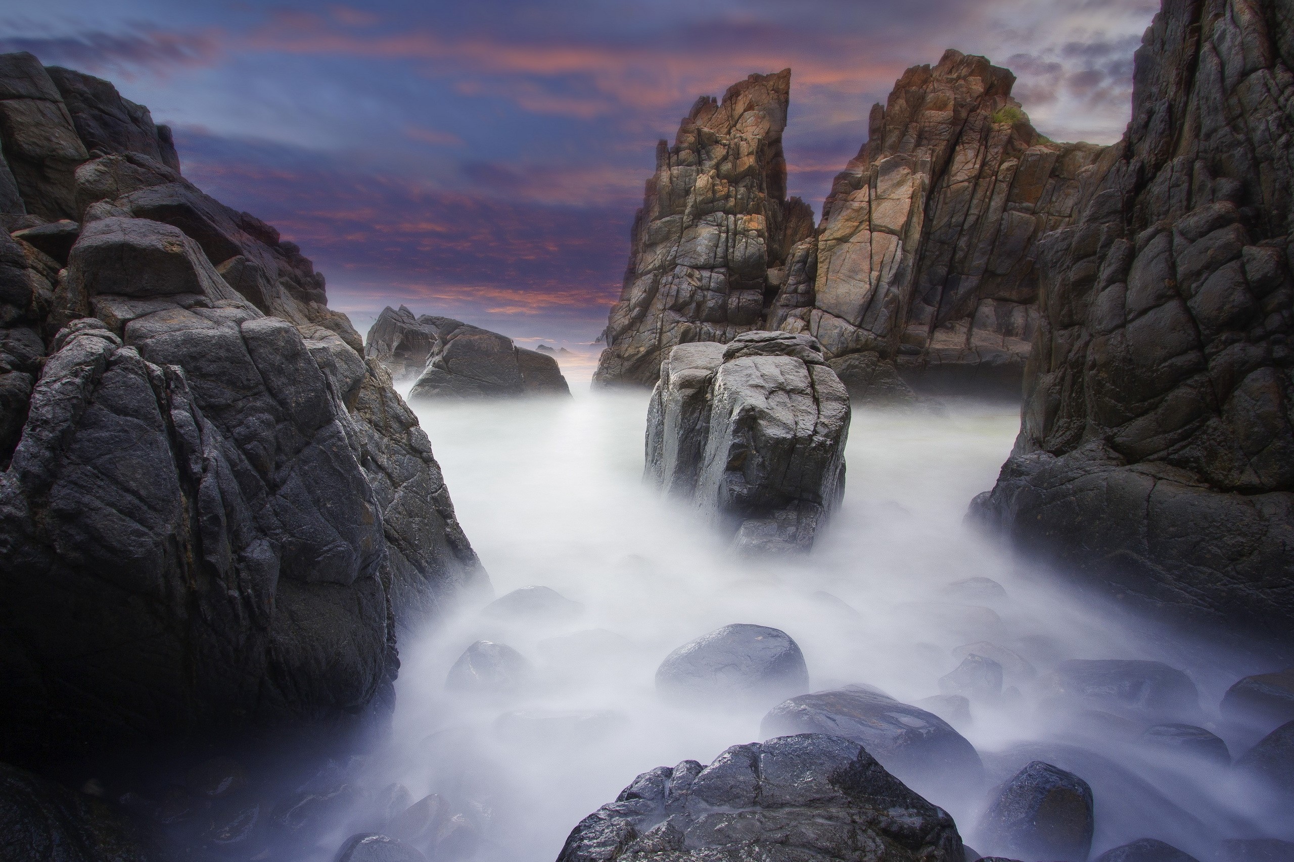 Rocky coastline with misty ocean and dramatic sky HD Wallpaper