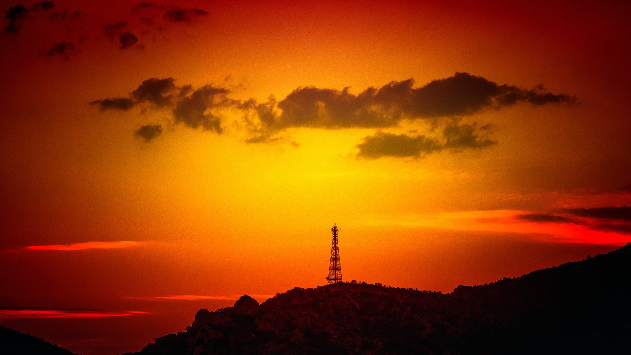 Silhouette of a radio tower on a hill during sunset HD Wallpaper