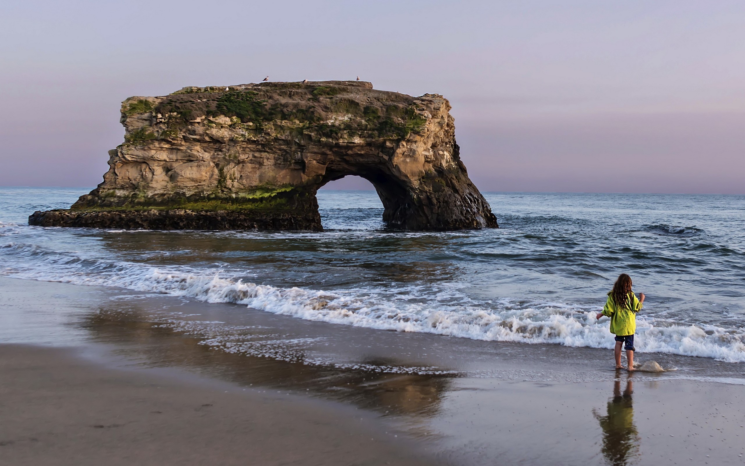 Girl on beach near Natural Bridges State Beach arch rock HD Wallpaper