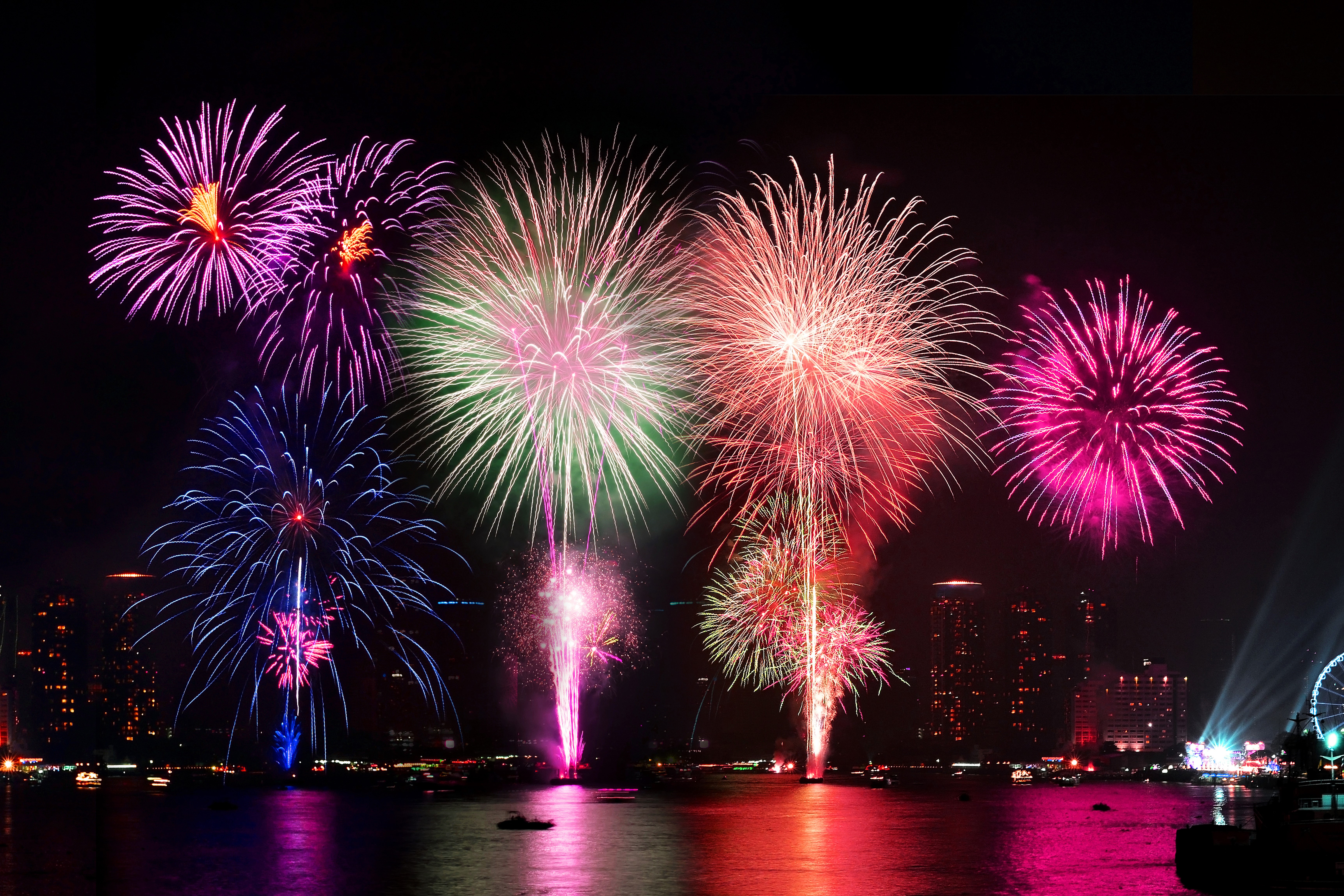 Fireworks over a city skyline at night HD Wallpaper