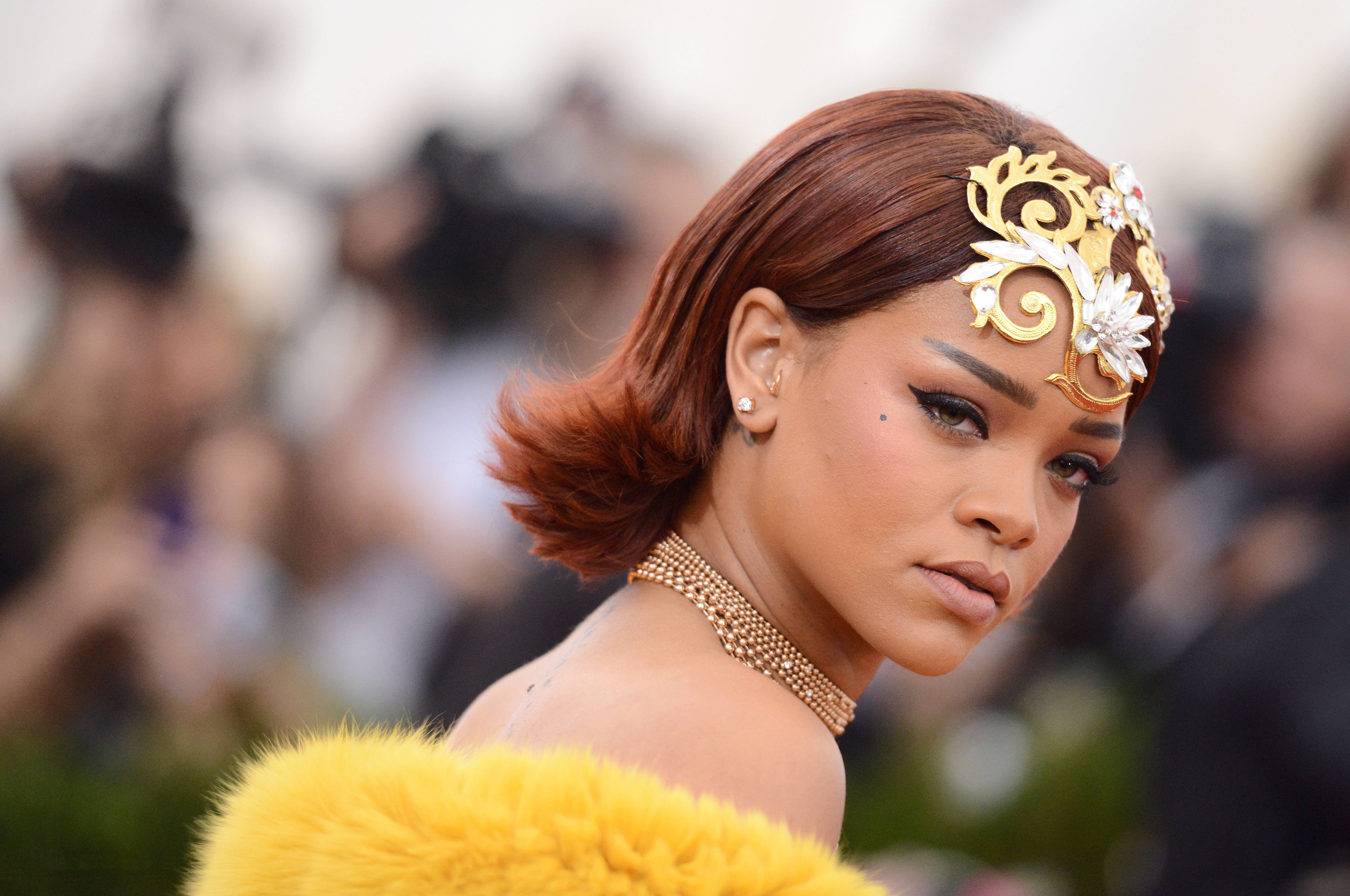 Rihanna wearing jewelry and a yellow fur coat HD Wallpaper