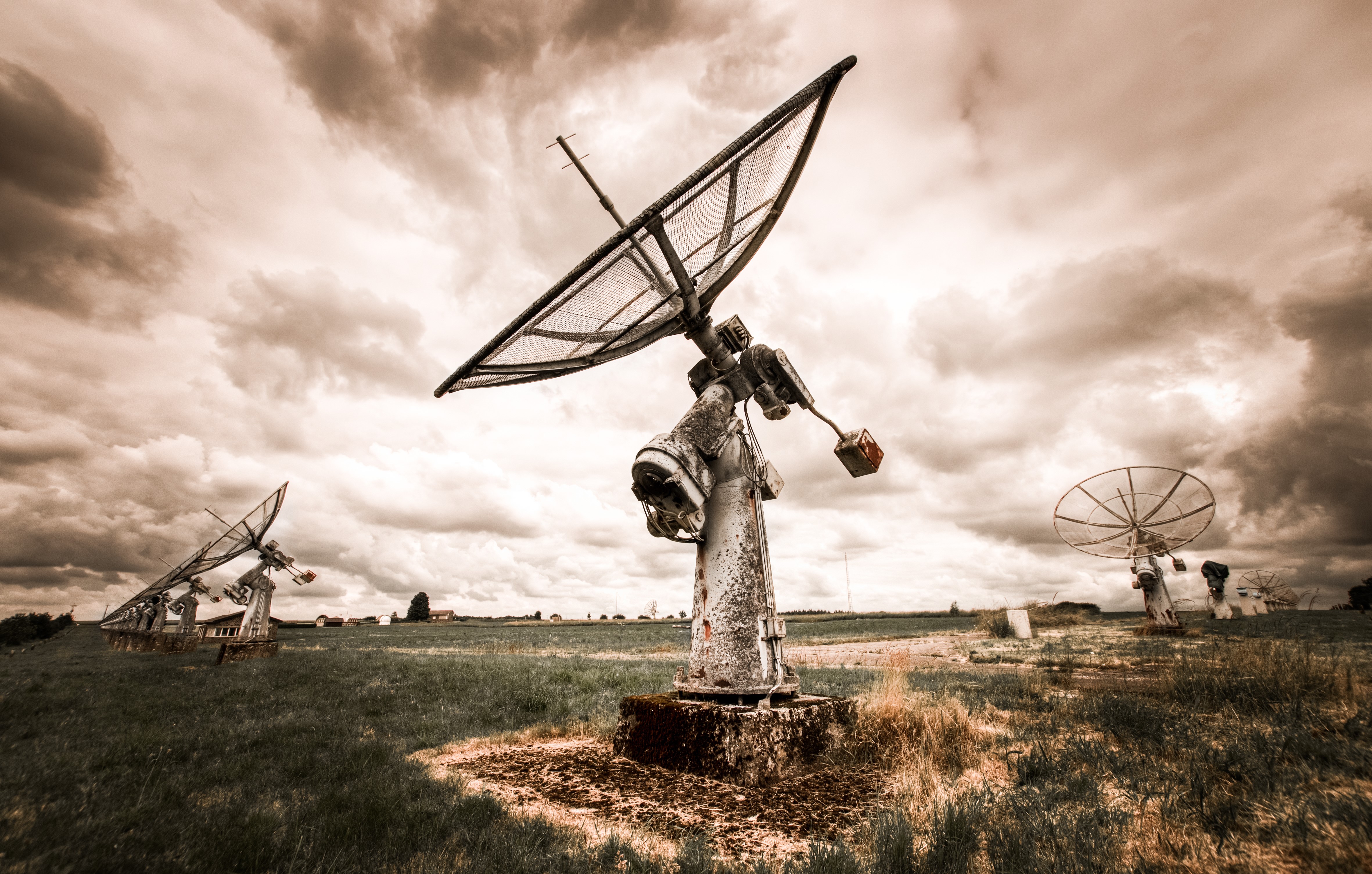 Abandoned Satellite Dishes in a Field Under Cloudy Sky HD Wallpaper