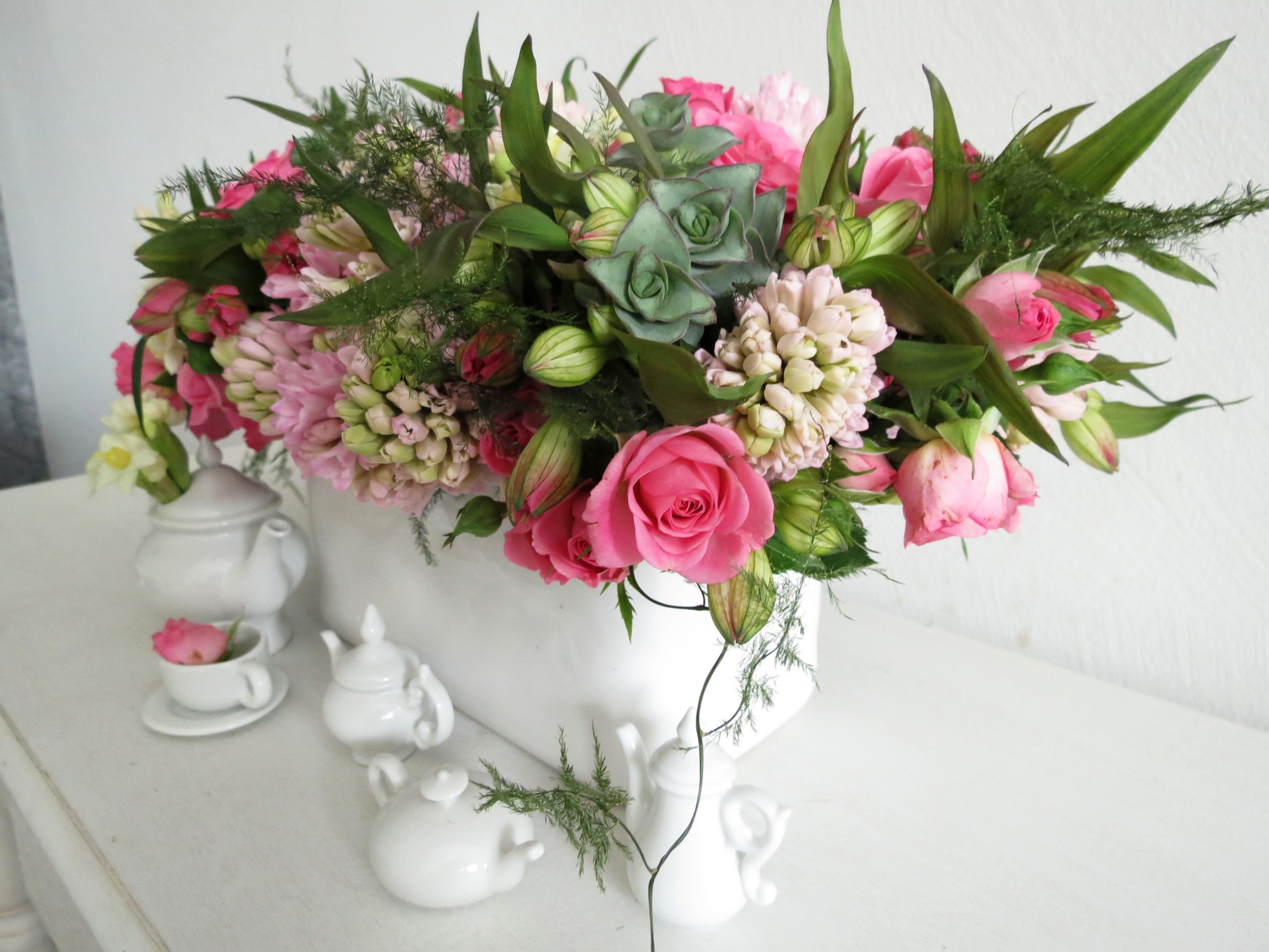 Floral arrangement with roses and hyacinths in a white vase with teacups HD Wallpaper