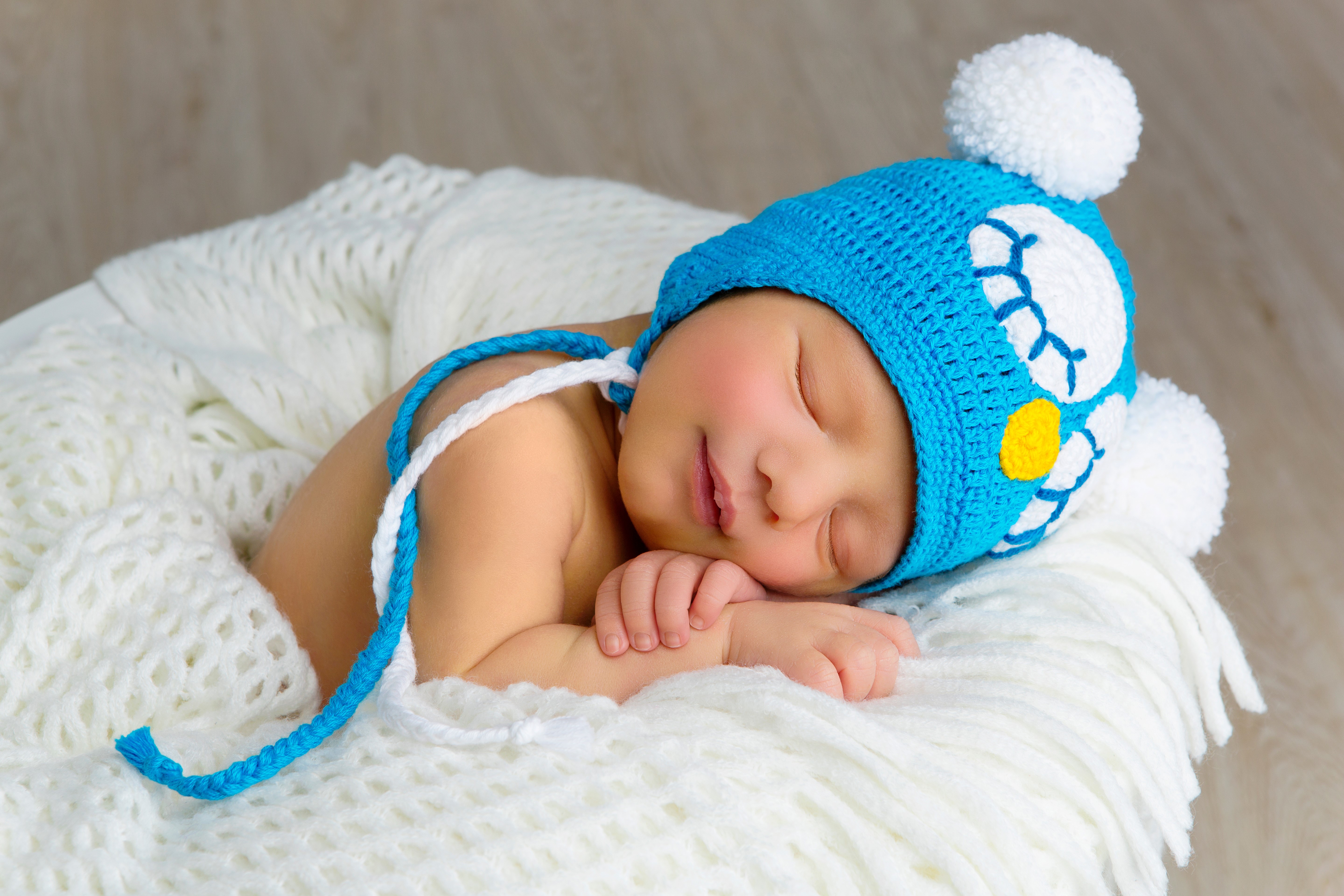 Newborn baby sleeping in a blue owl hat HD Wallpaper