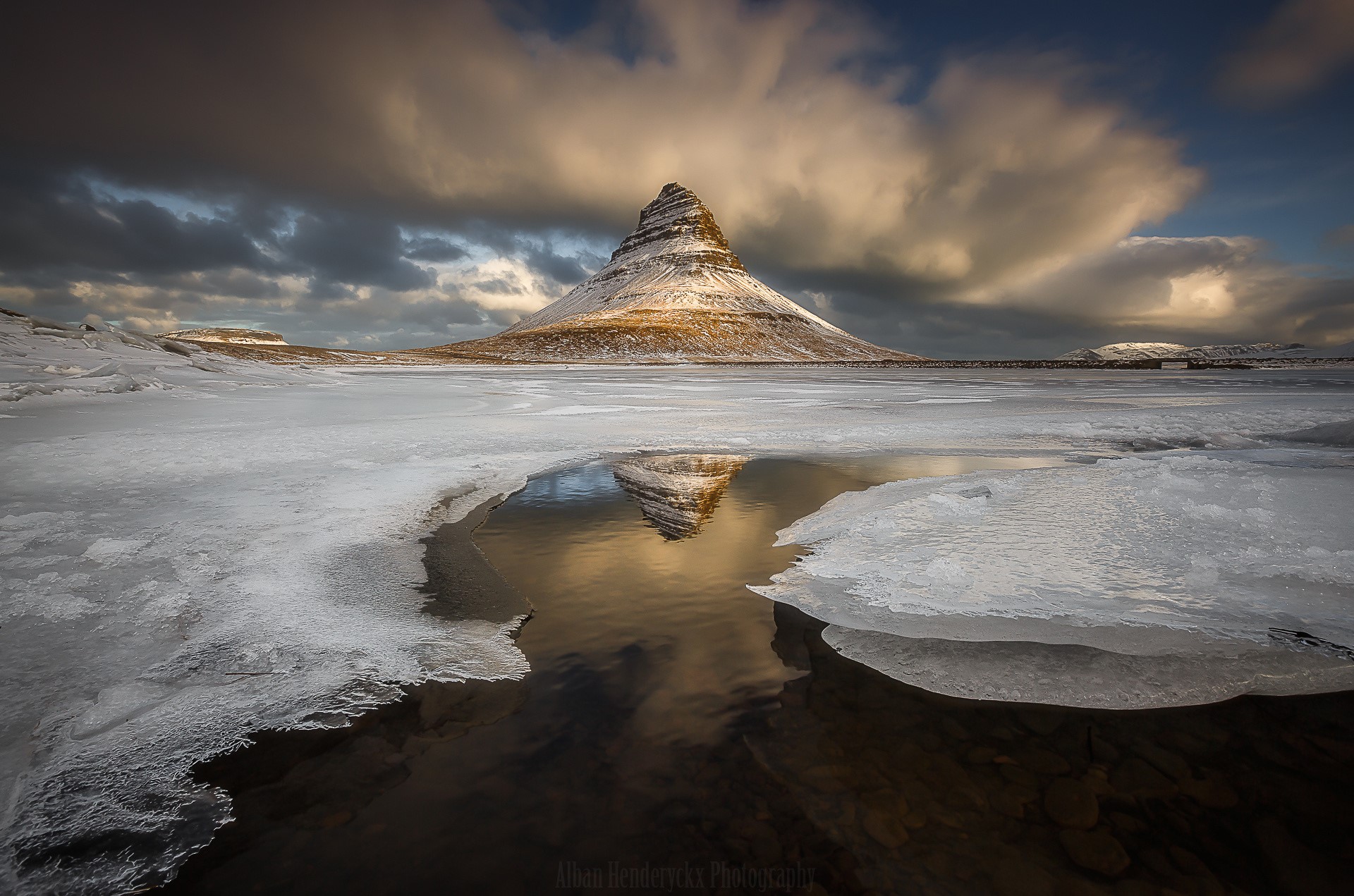 Kirkjufell mountain reflected in icy water in Iceland HD Wallpaper