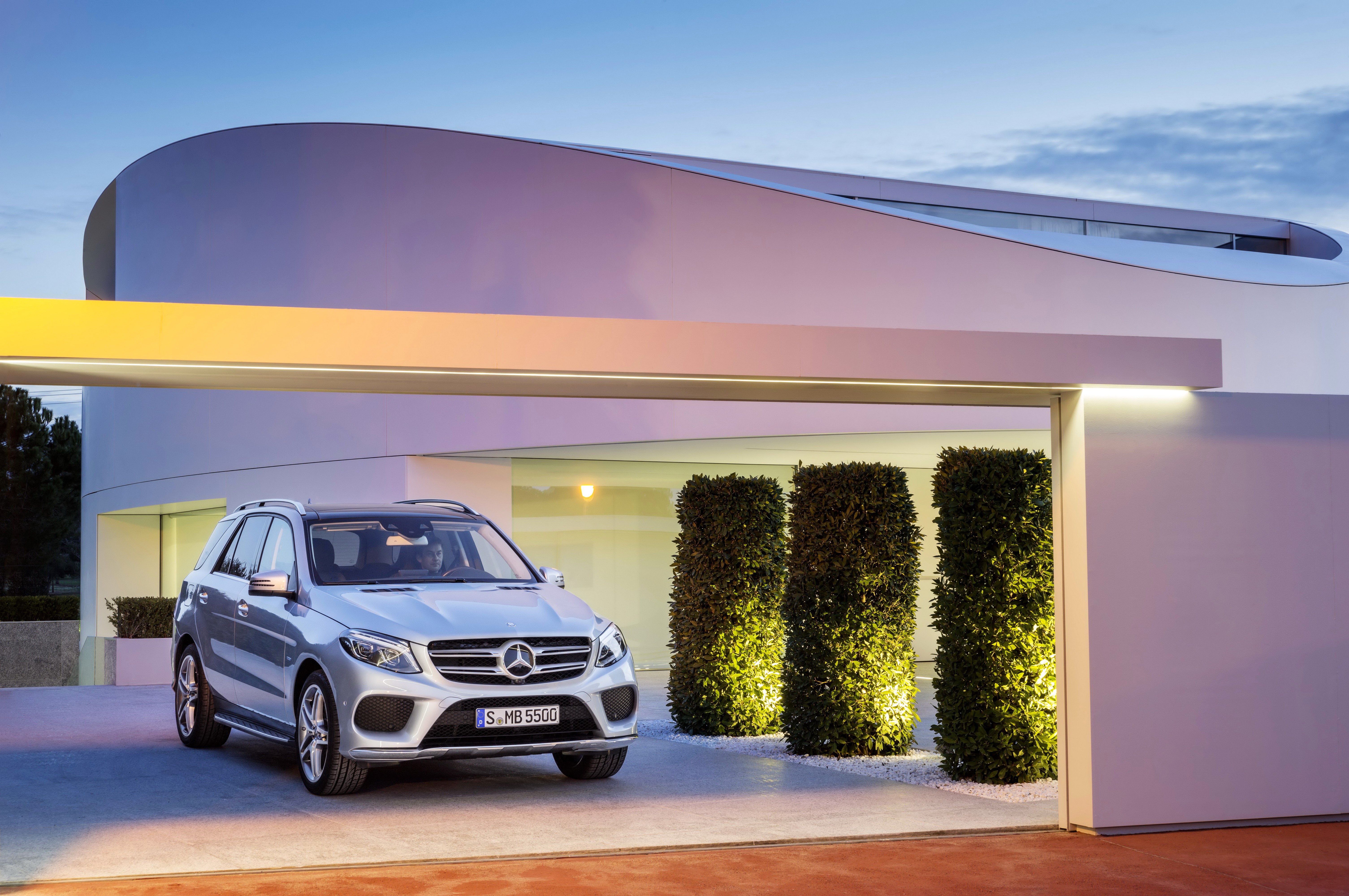 Silver Mercedes-Benz GLE 500 parked in front of modern architecture HD Wallpaper