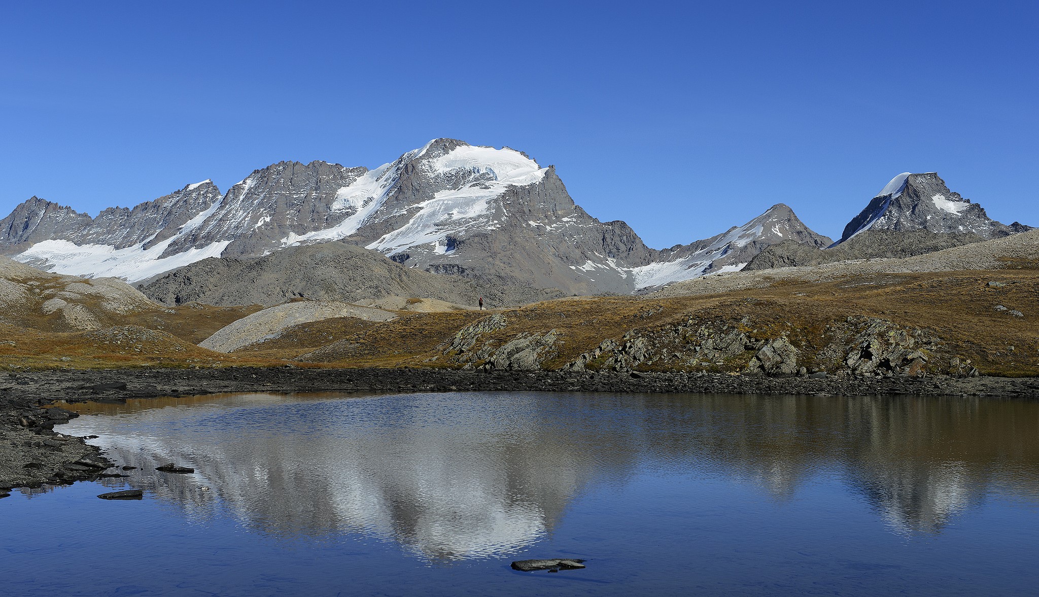Mountains reflected in a lake under a clear blue sky HD Wallpaper