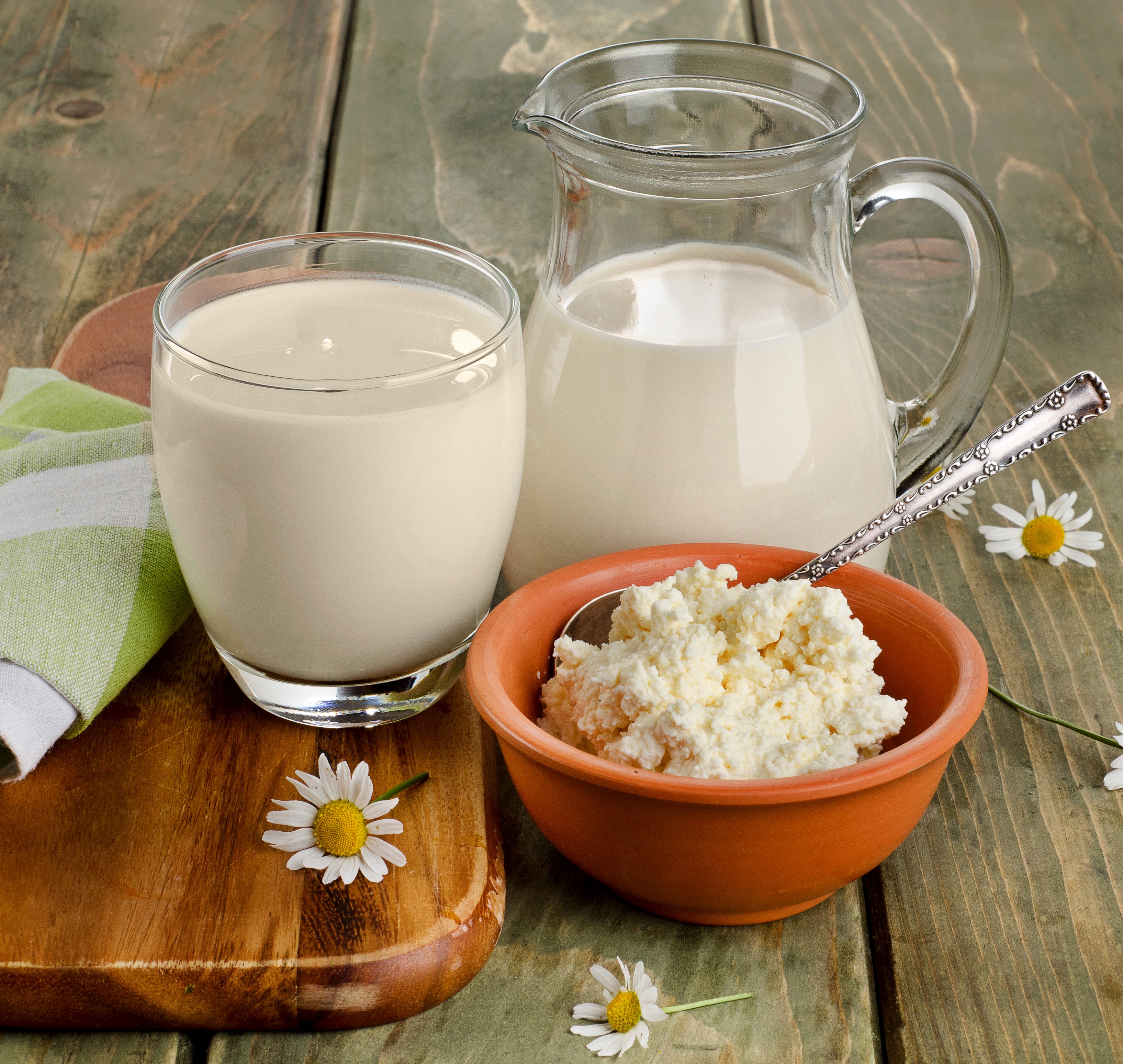 Milk and cheese with daisies on a wooden table HD Wallpaper
