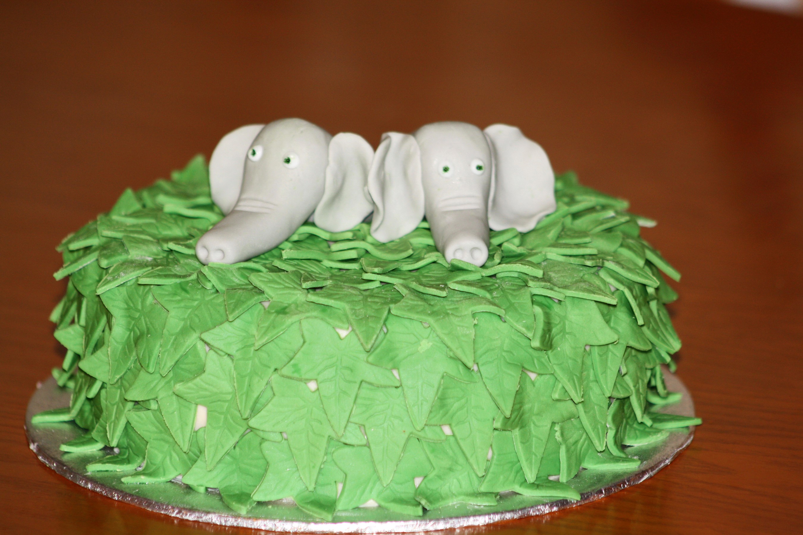 Cake decorated with green leaves and two elephant figures HD Wallpaper