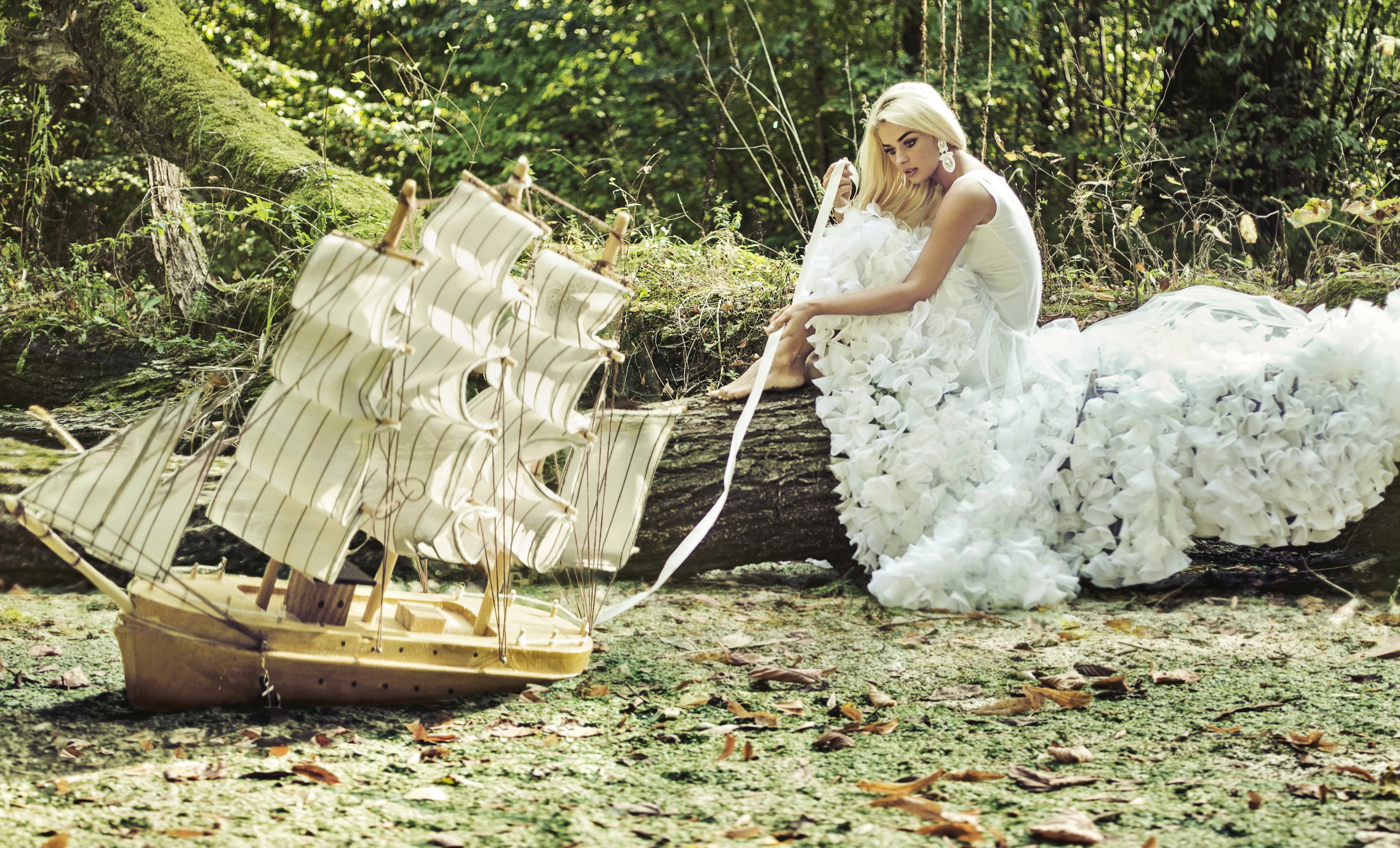 Blonde girl in white dress with model ship in forest HD Wallpaper