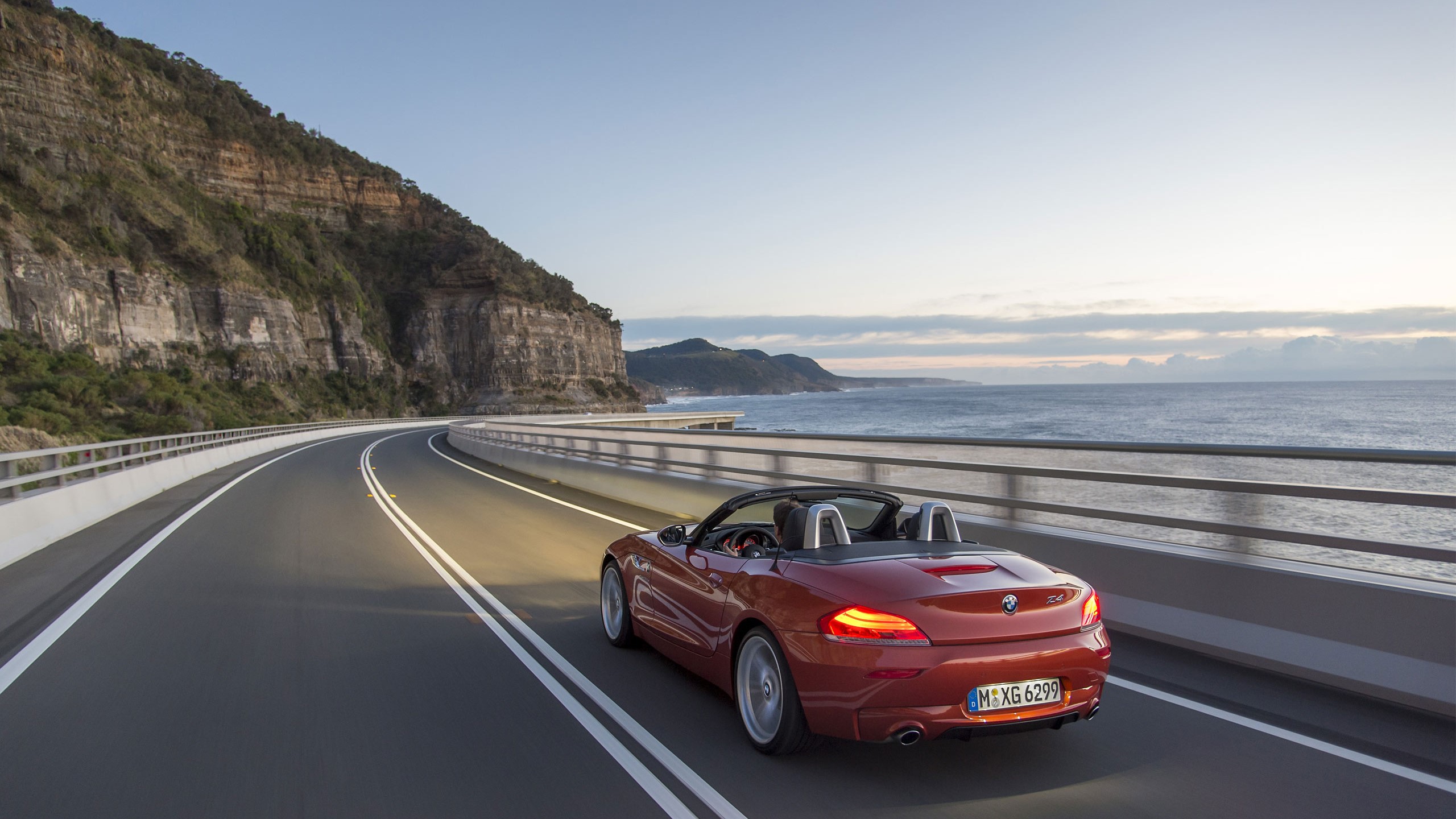 Red BMW Z4 Cabriolet driving on a coastal road HD Wallpaper