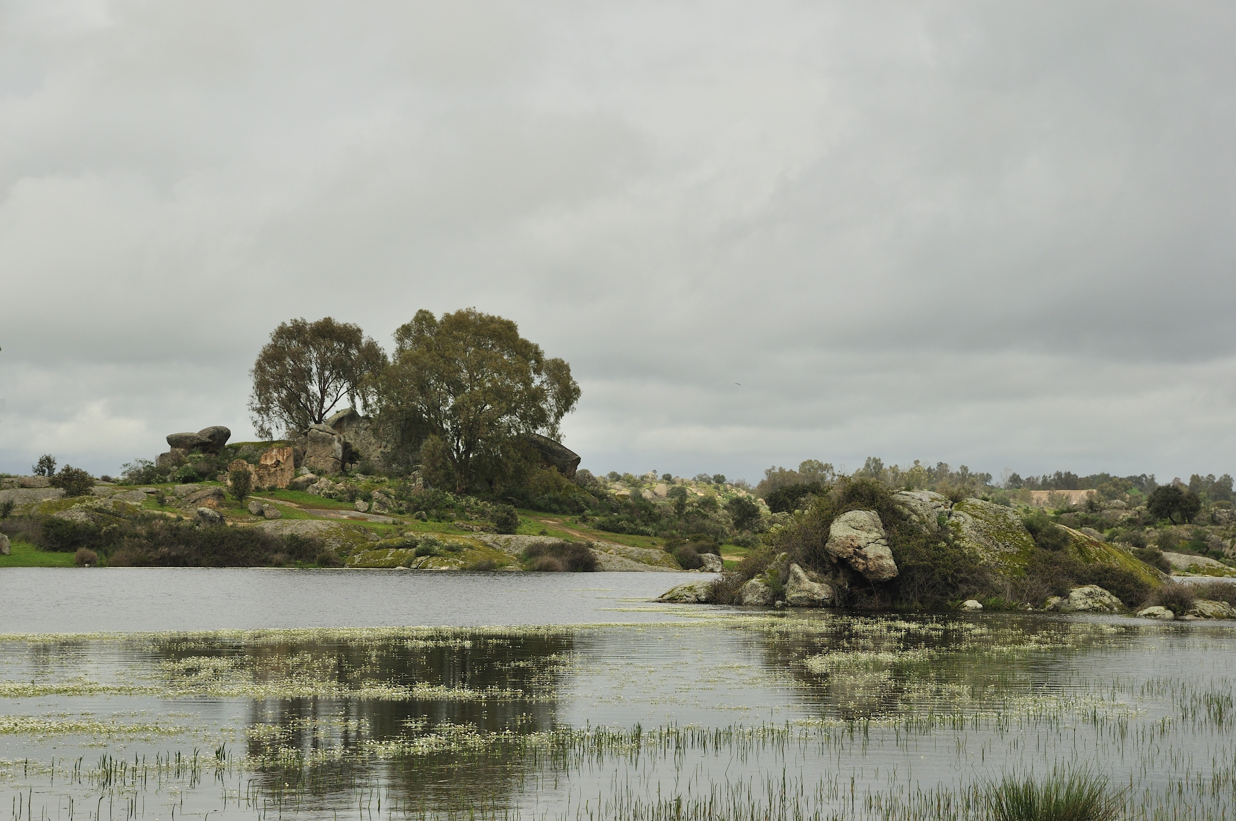 Rocky landscape with a lake under cloudy sky HD Wallpaper