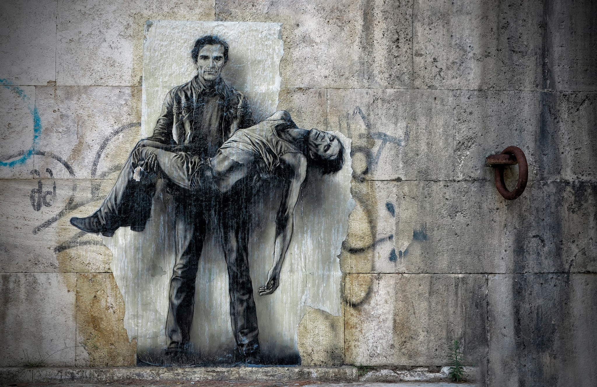 Graffiti of a man carrying another man on a wall HD Wallpaper