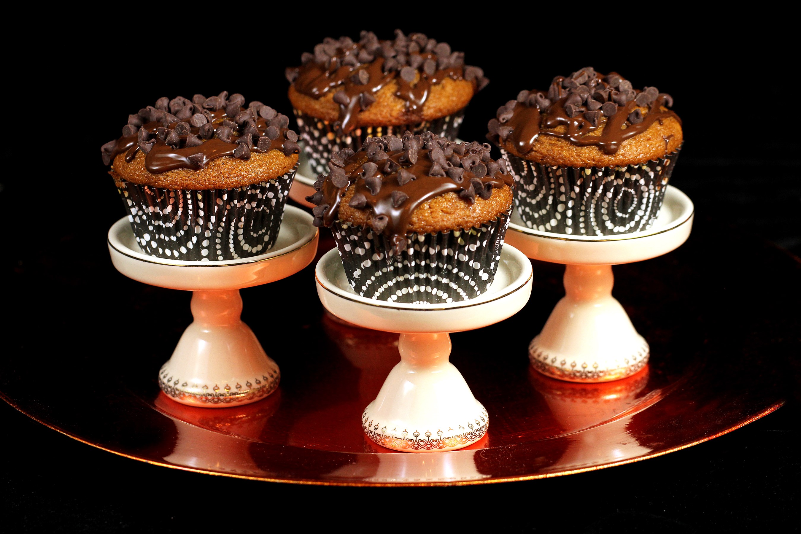 Four chocolate chip cupcakes on pedestals HD Wallpaper