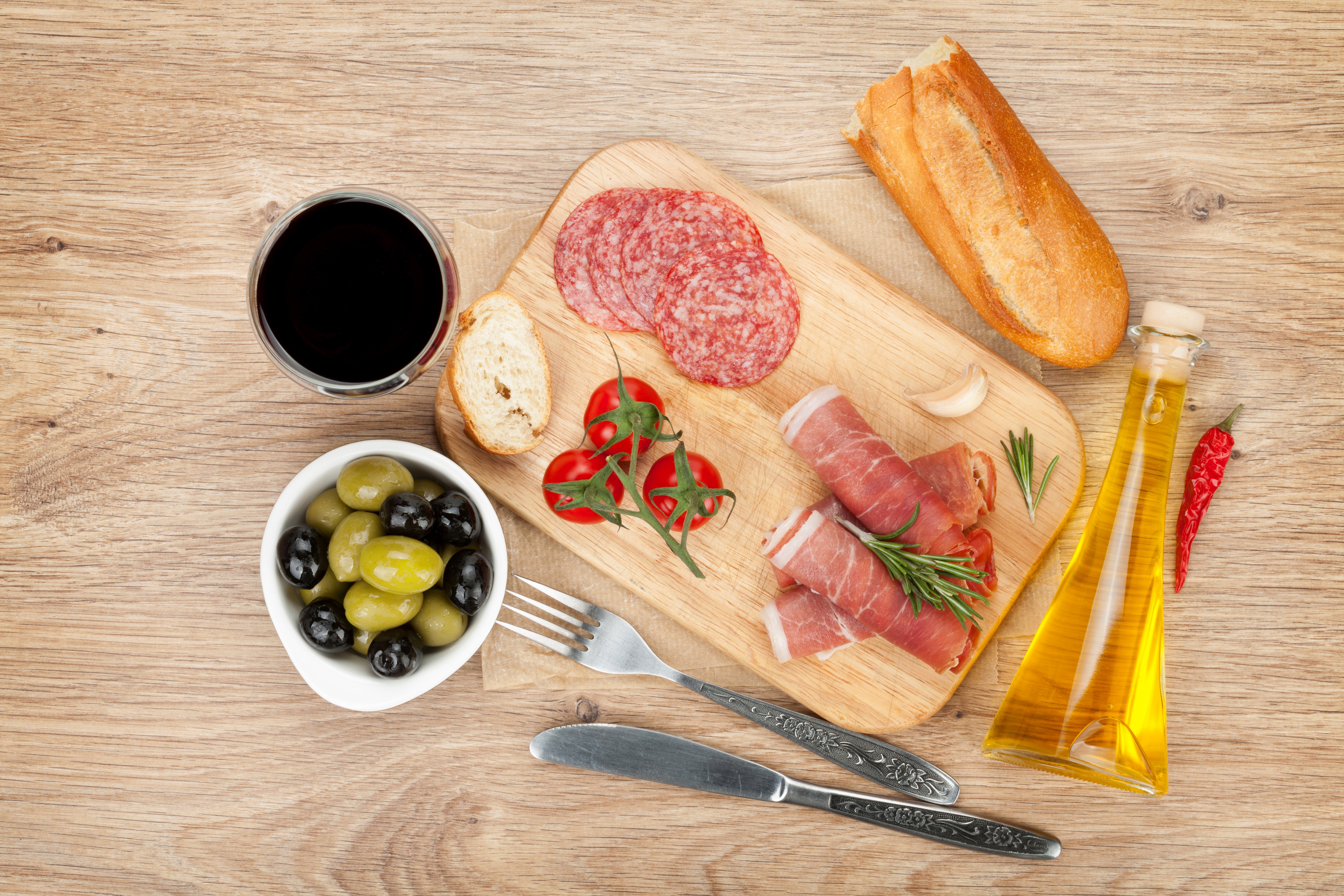Charcuterie board with salami, ham, olives, tomatoes, bread, and wine HD Wallpaper