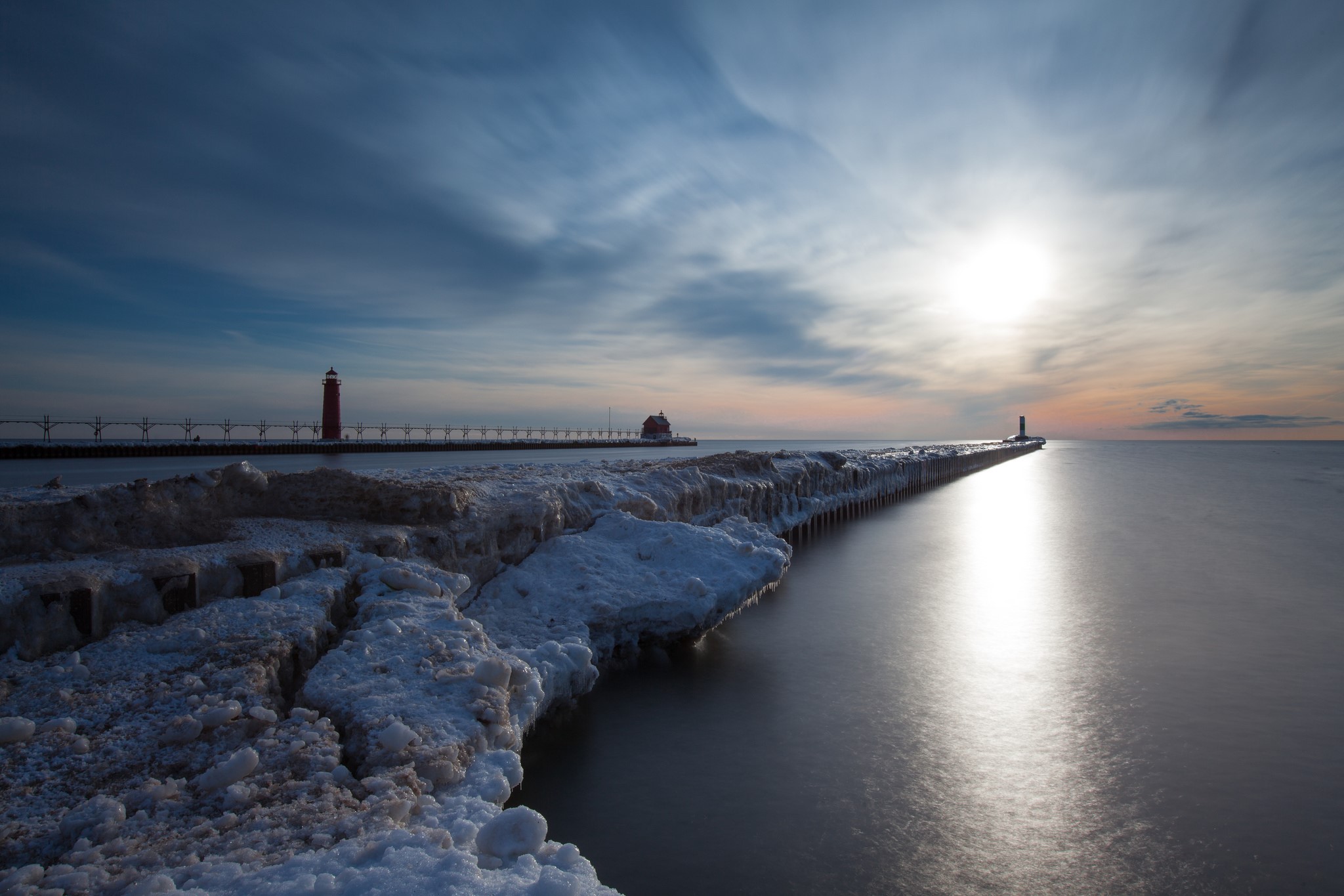 Winter lighthouse pier on a frozen lake at sunset HD Wallpaper