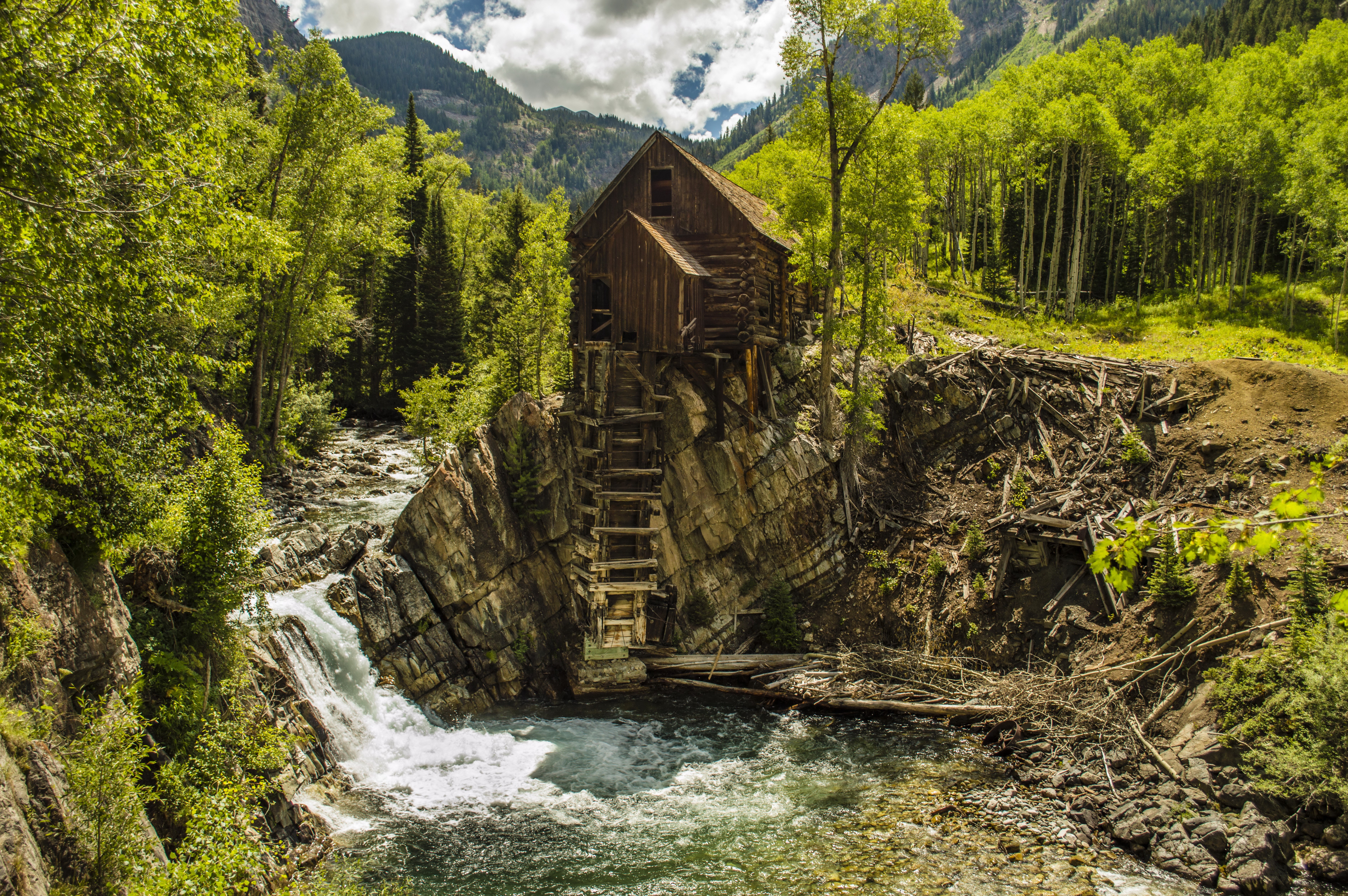 Wooden Mill on a Rocky Outcrop by a River HD Wallpaper