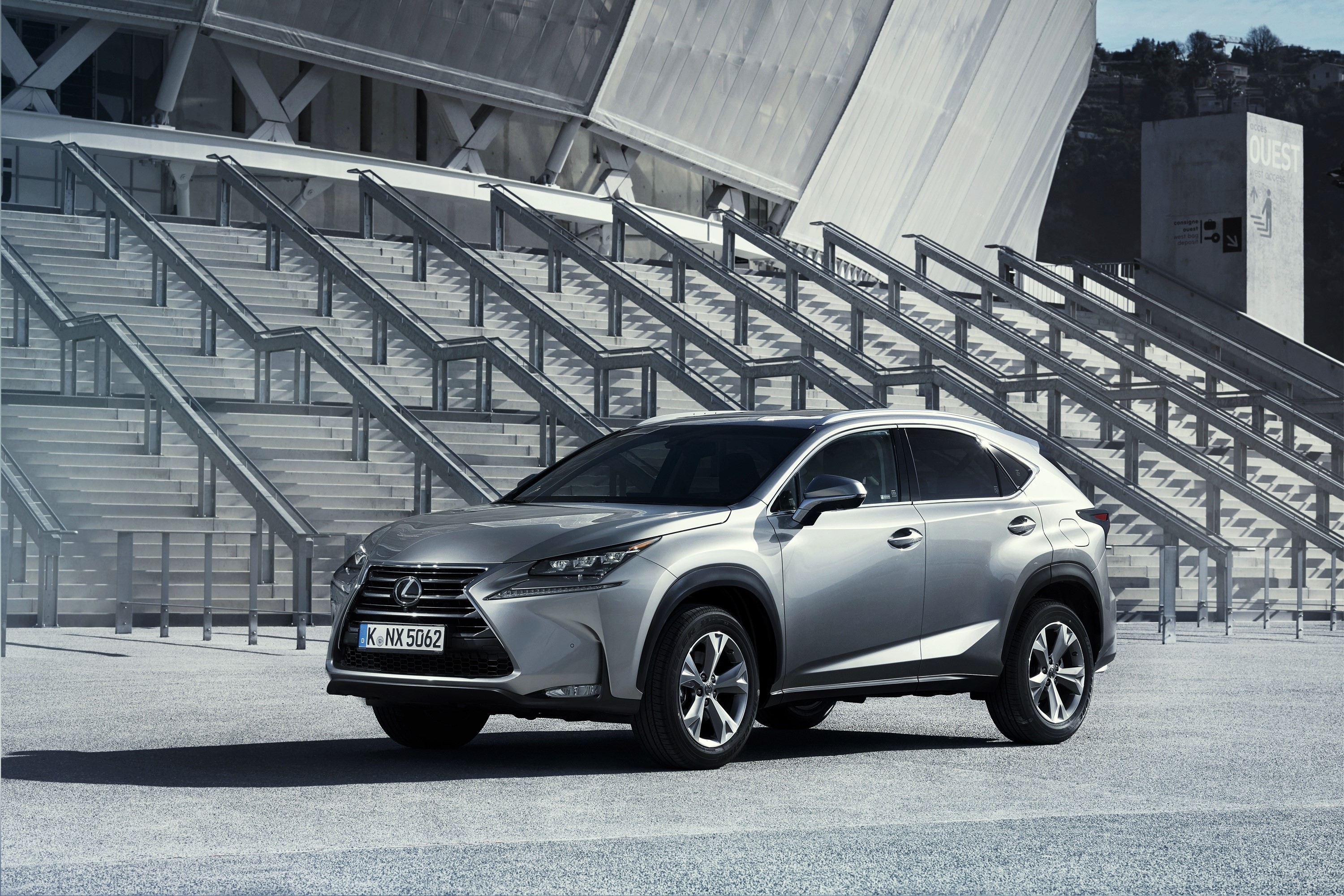 Silver Lexus NX 300h parked in front of a modern building HD Wallpaper