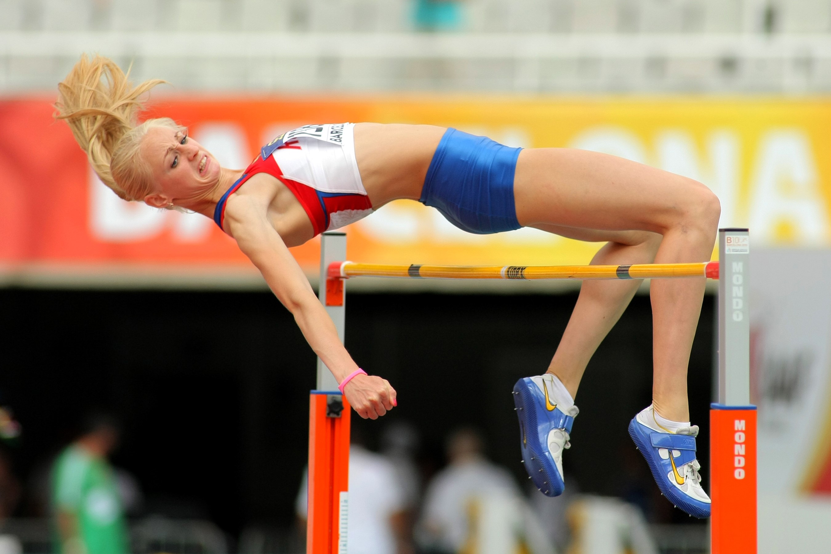 Blonde athlete high jumping over a bar HD Wallpaper