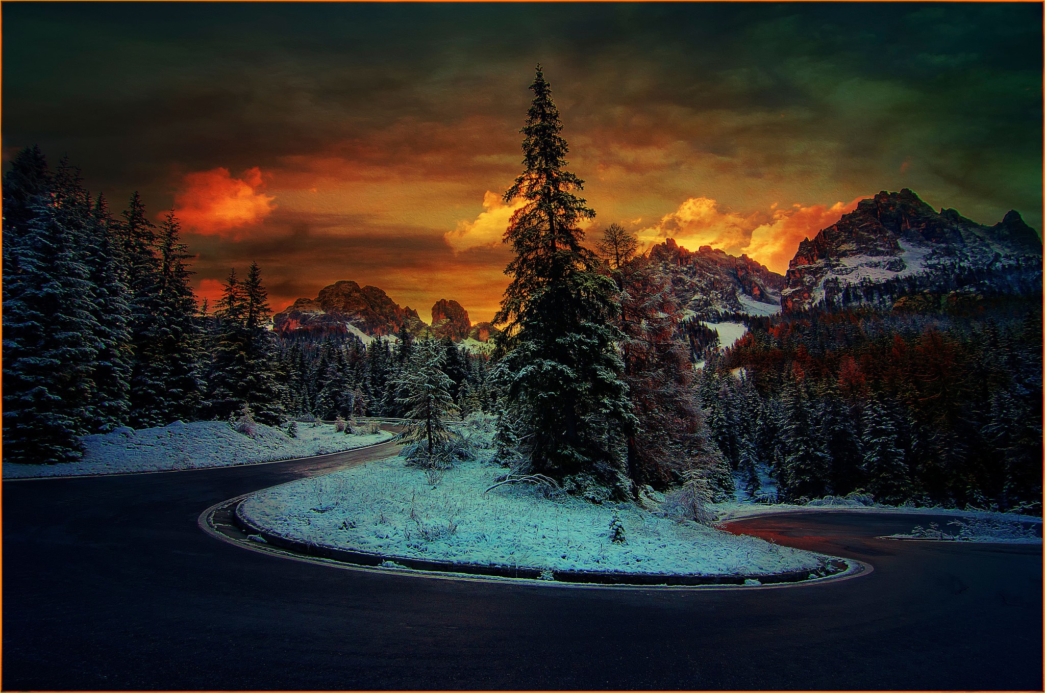Winding mountain road through snowy forest at sunset HD Wallpaper
