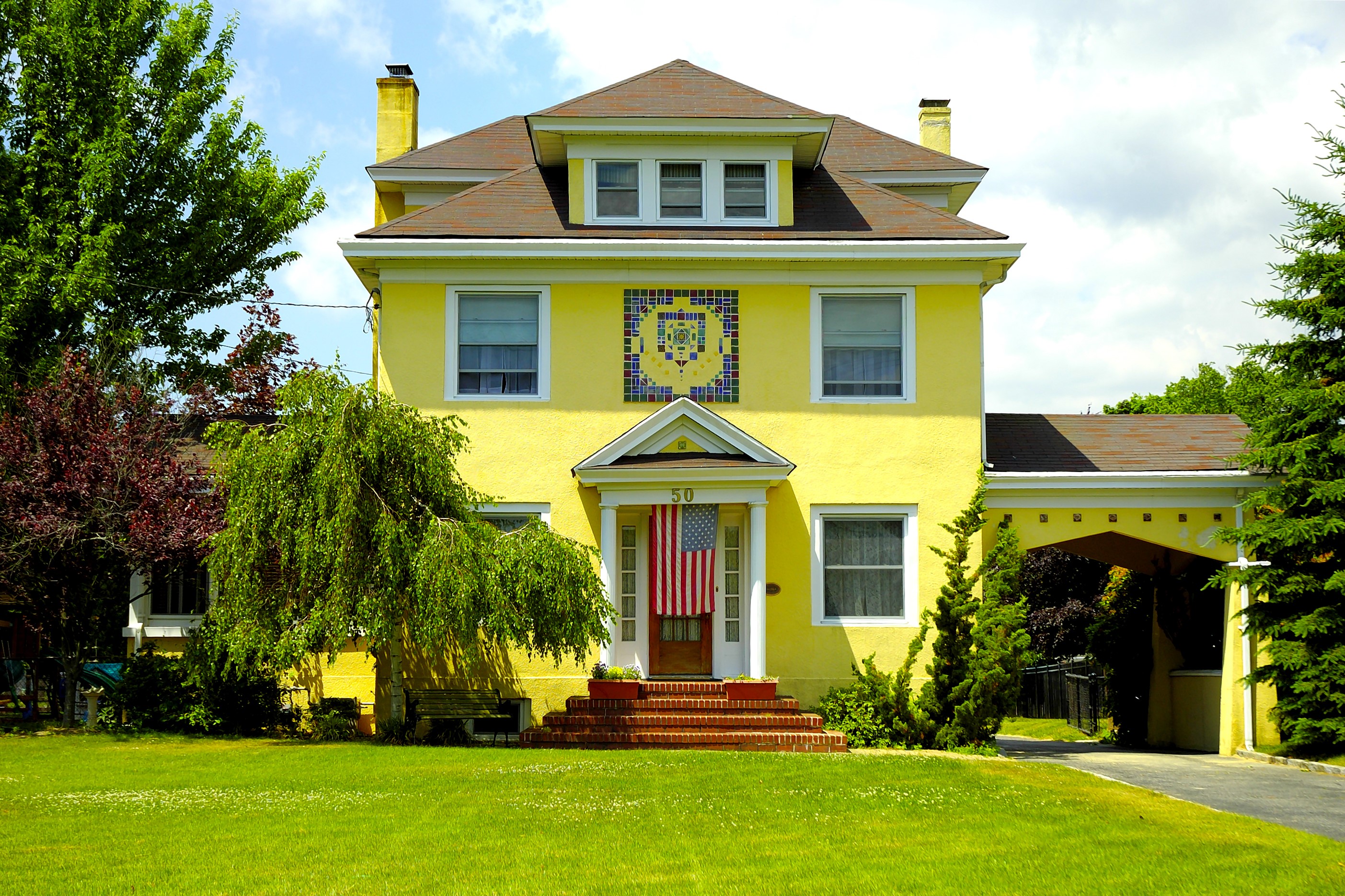 Yellow house with American flag and trees HD Wallpaper
