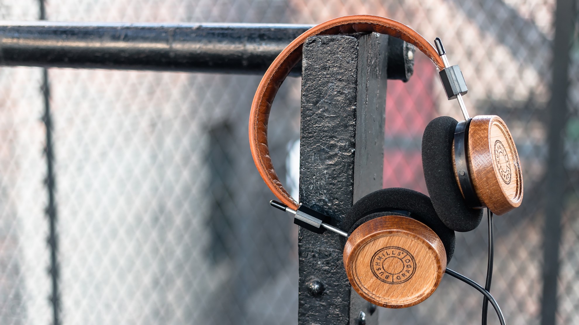 Wooden headphones hanging on a metal post HD Wallpaper