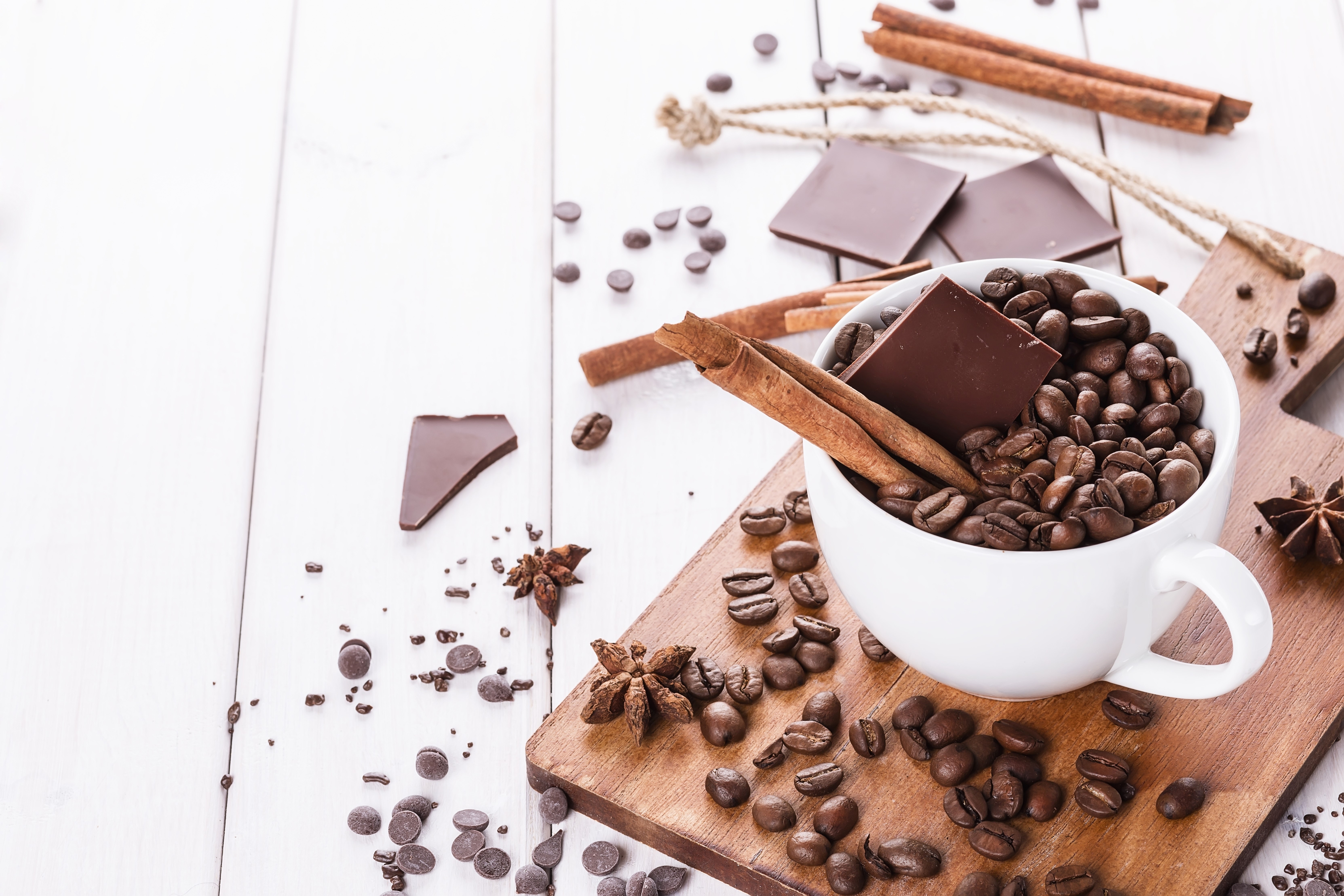 Coffee beans, chocolate, and cinnamon sticks in a cup HD Wallpaper