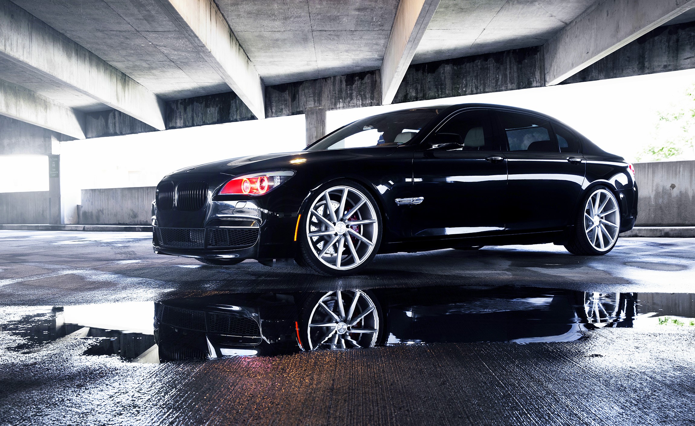 Black BMW 750LI parked in a concrete structure HD Wallpaper