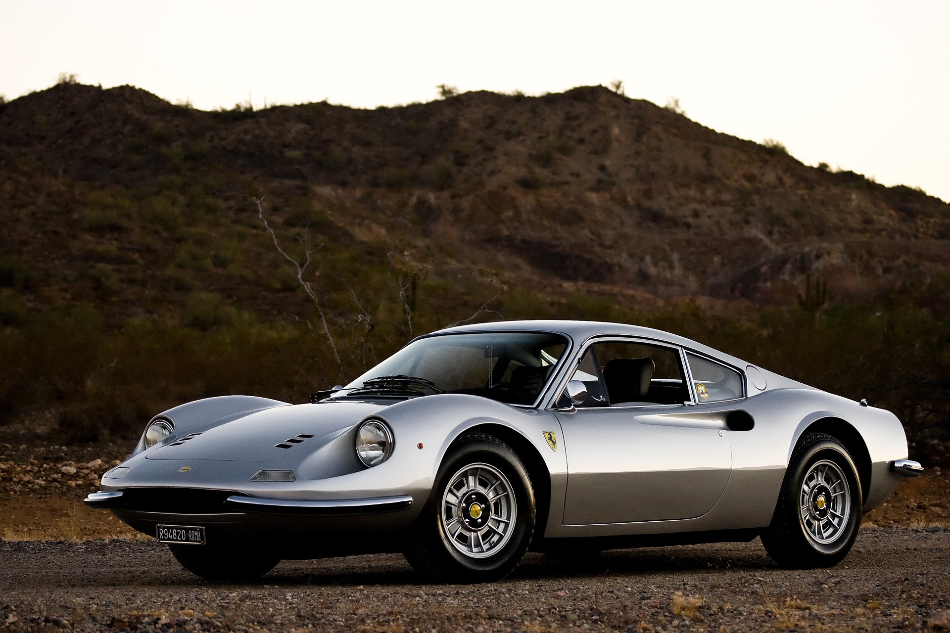 Silver Ferrari 246 GT in a desert landscape HD Wallpaper