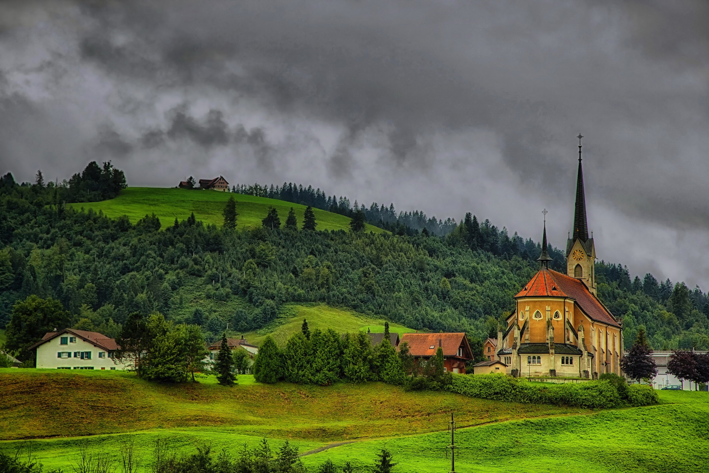 Church and houses in a mountainous landscape in Switzerland HD Wallpaper