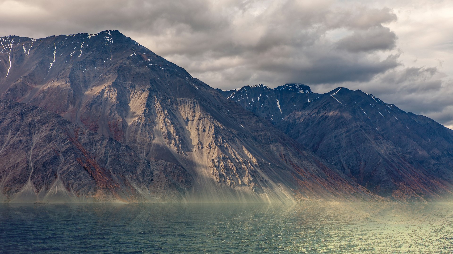 Mountains reflecting in the sea under cloudy sky HD Wallpaper