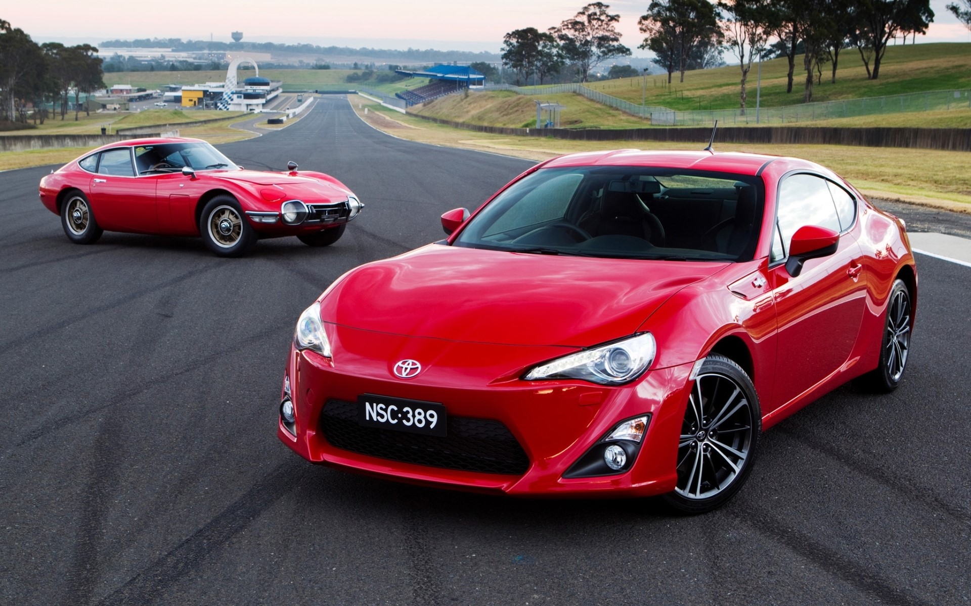 Two red Toyota sports cars on a race track HD Wallpaper