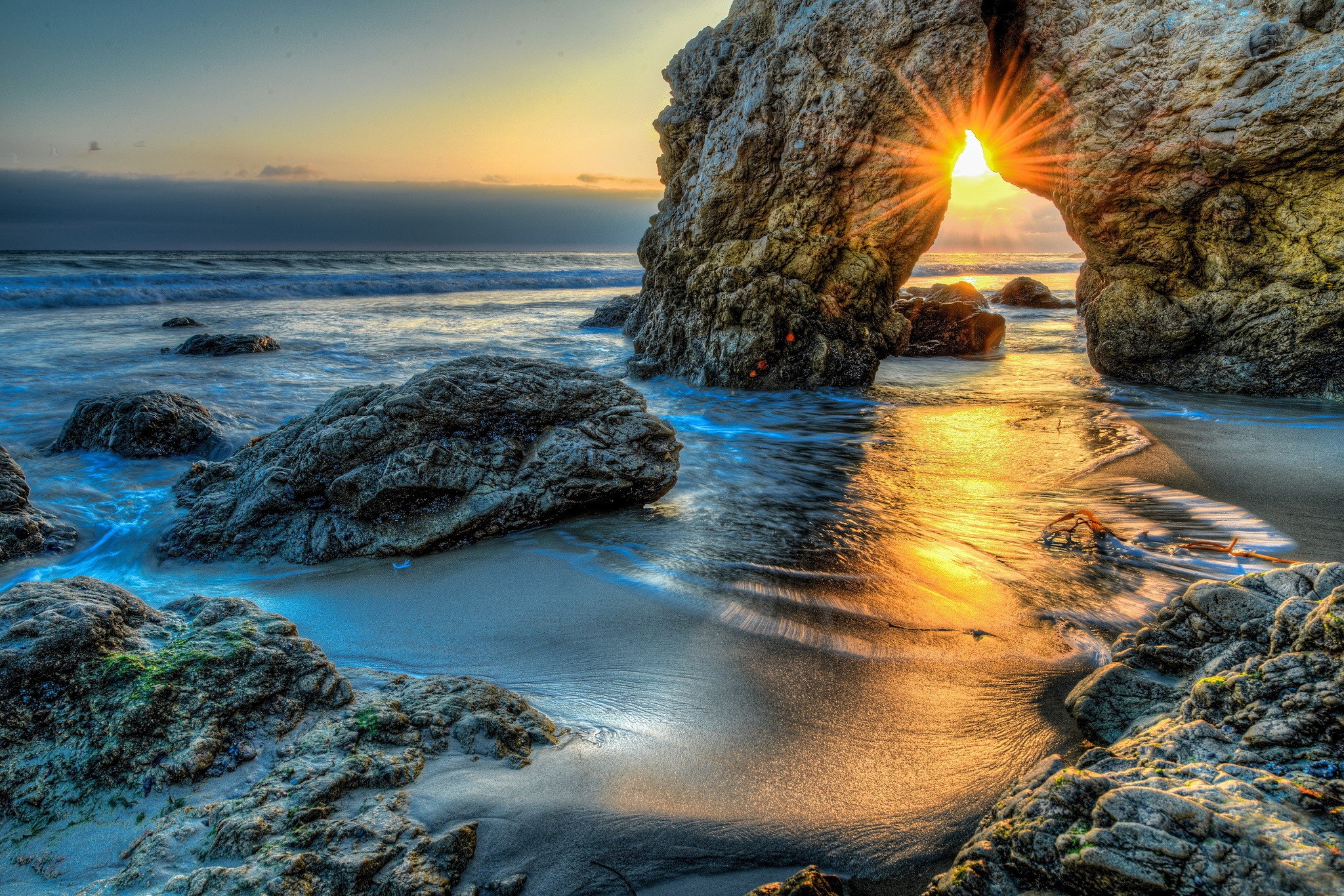 Sunset through rock arch at Malibu beach HD Wallpaper