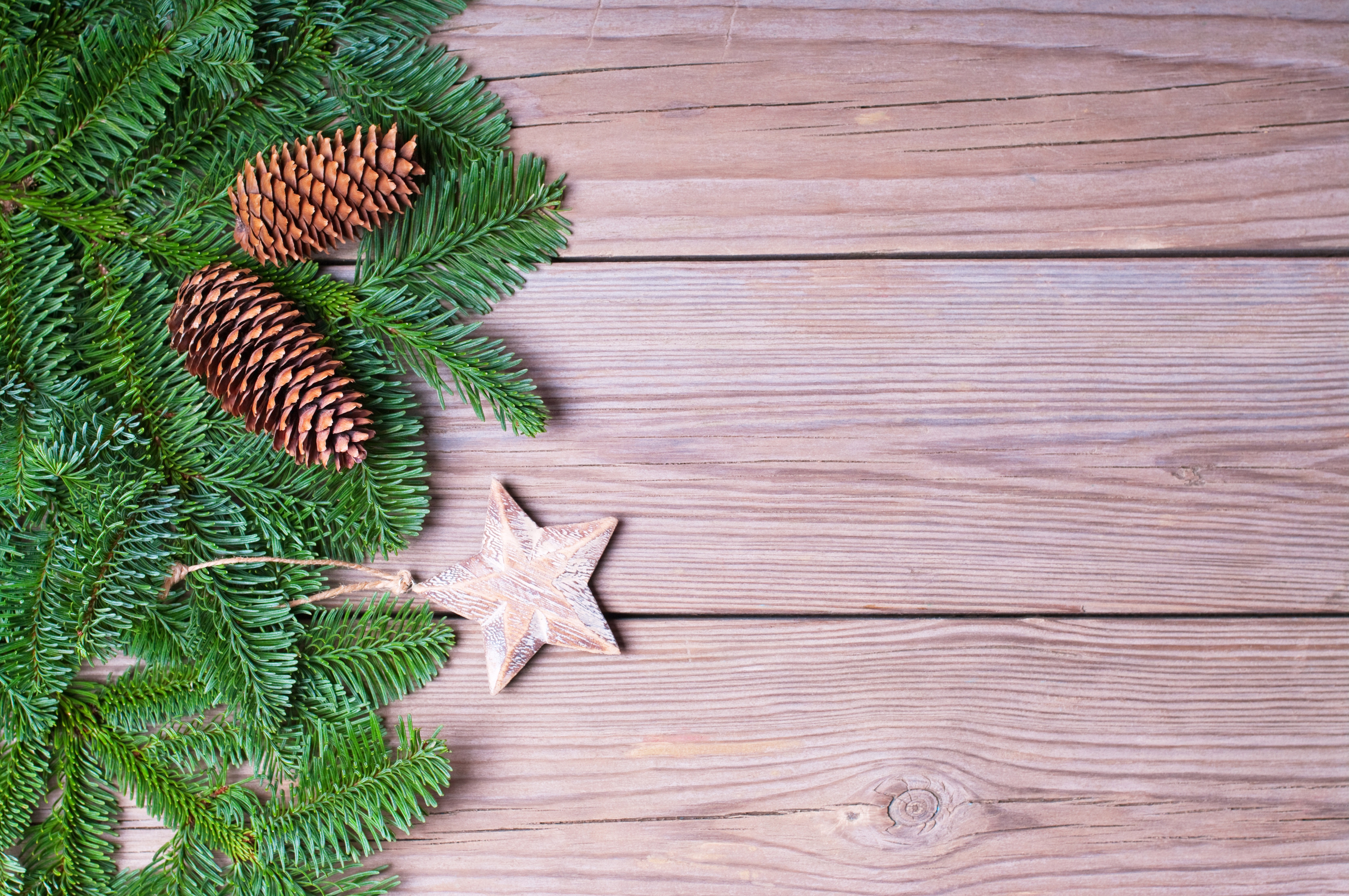 Christmas fir branches with pine cones and star ornament on wood HD Wallpaper