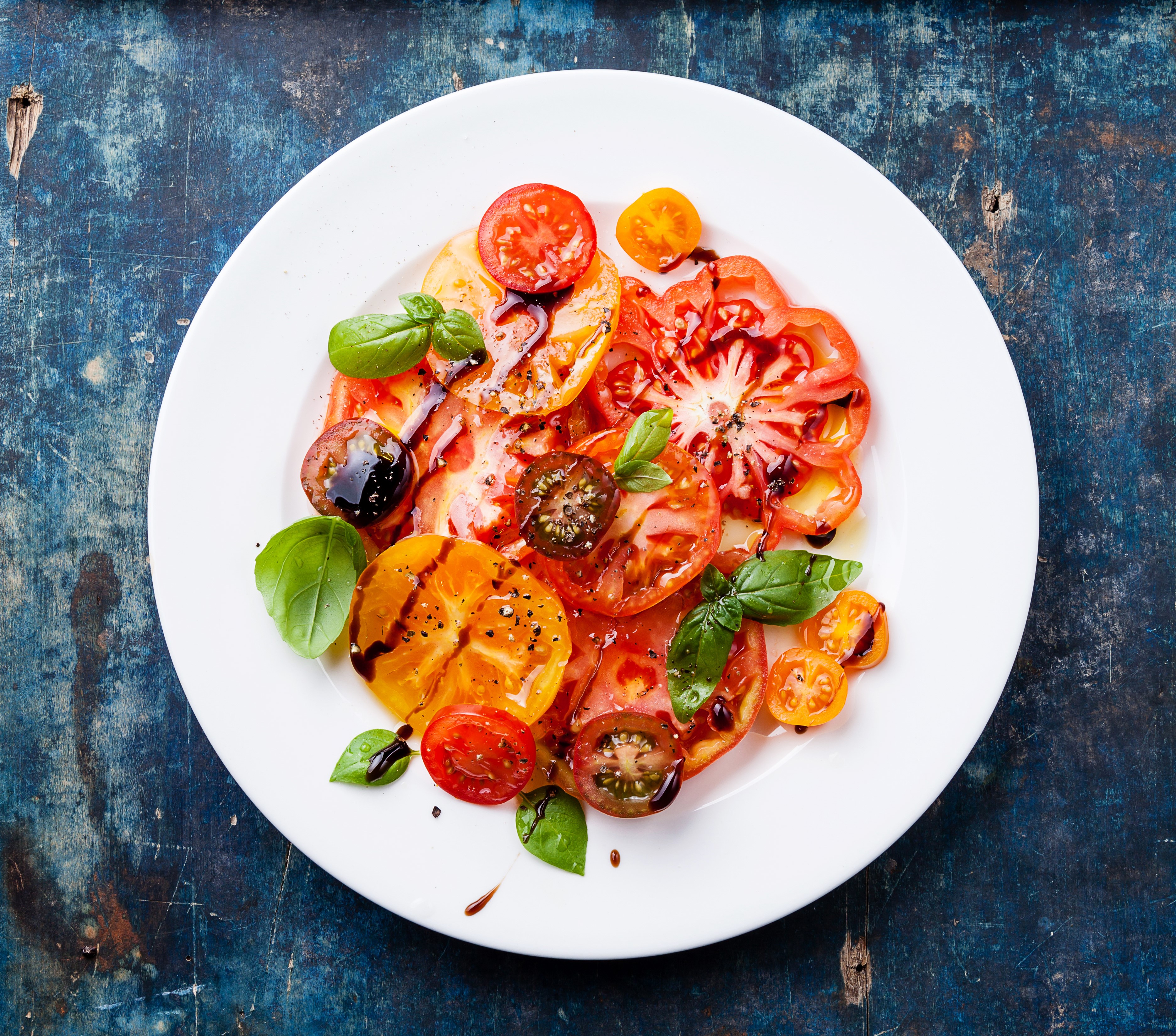 Sliced tomatoes and basil on a white plate HD Wallpaper