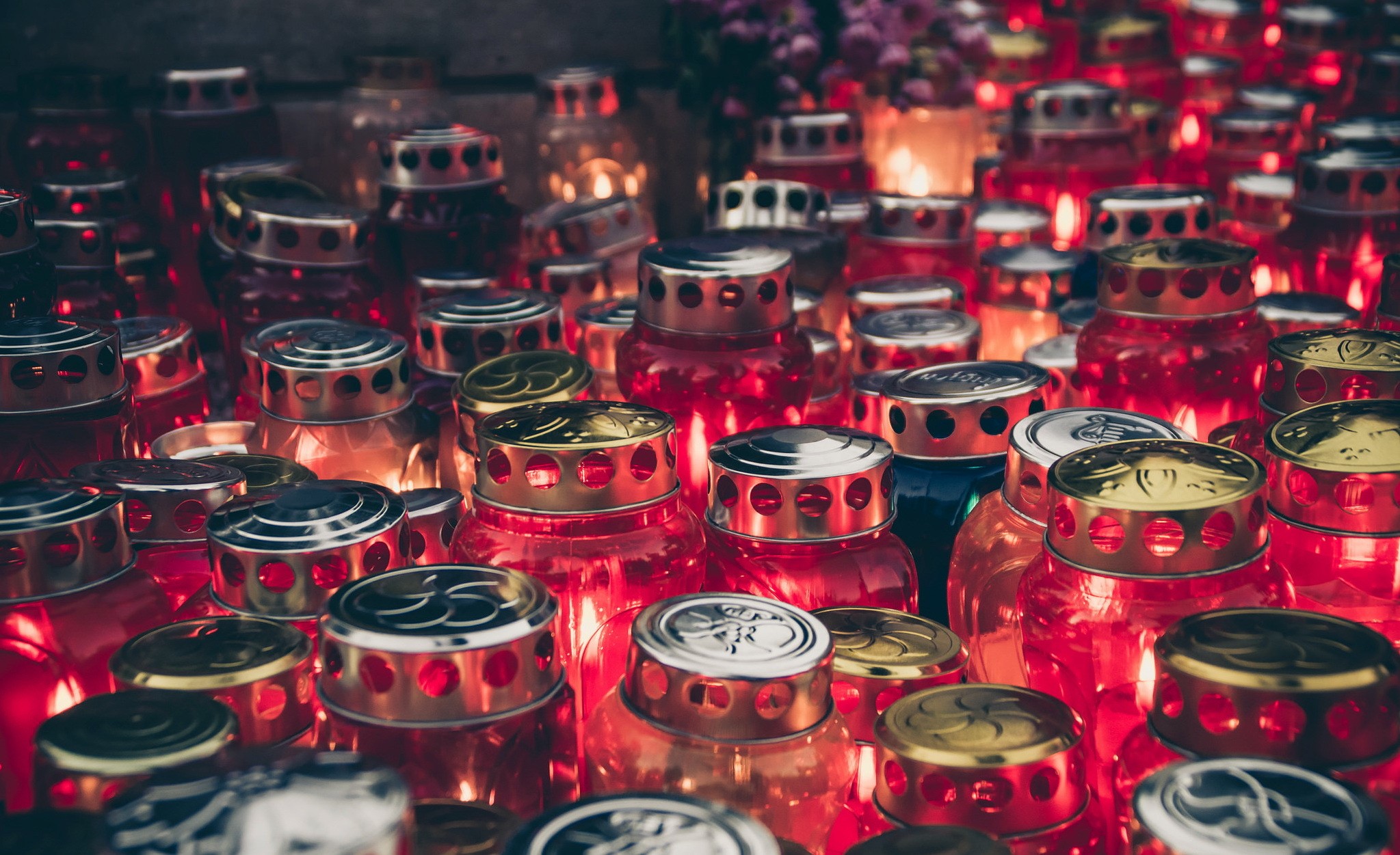 Many red glass candle jars with lit flames HD Wallpaper