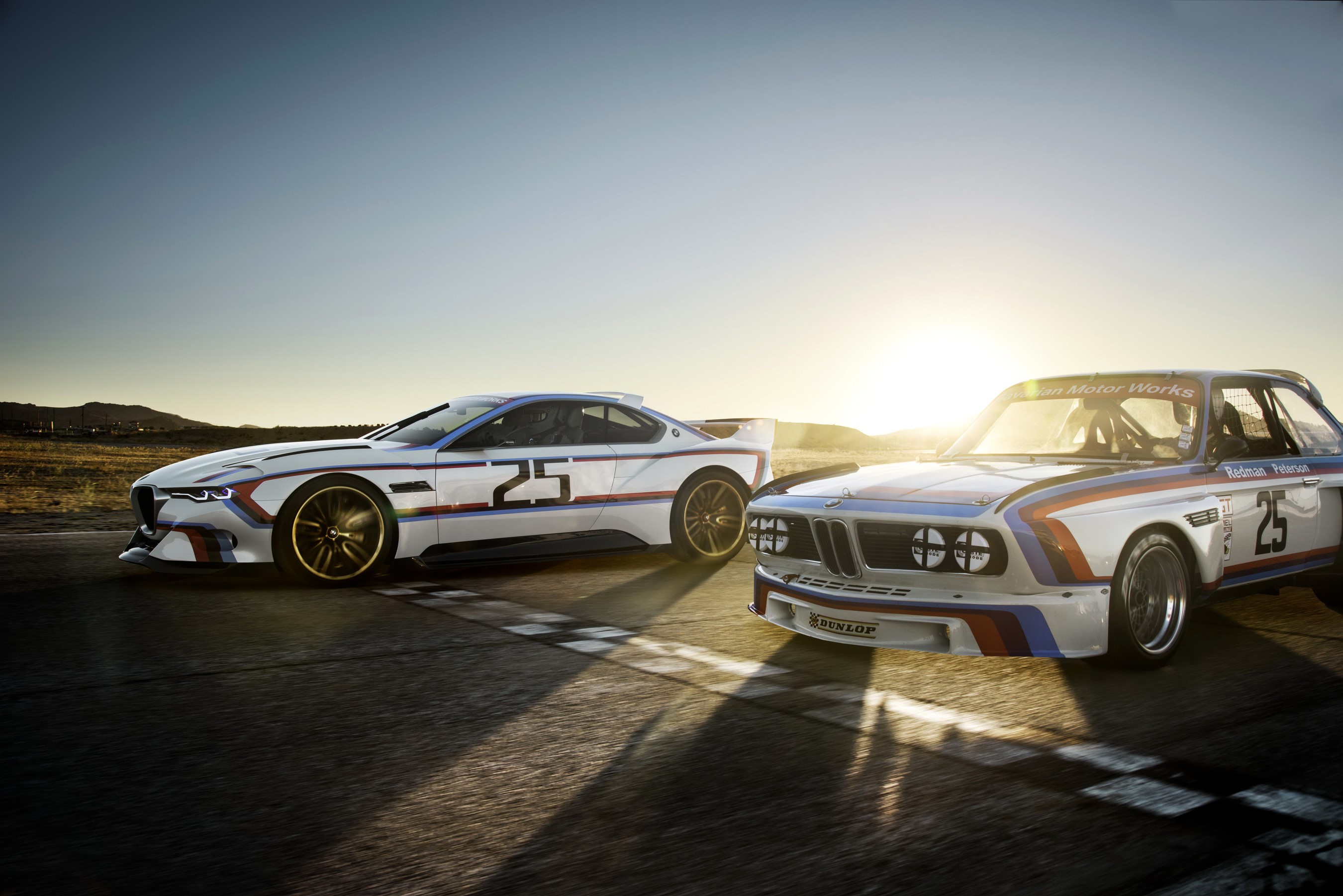 Two BMW 3.0 CSL Hommage cars on a racetrack HD Wallpaper