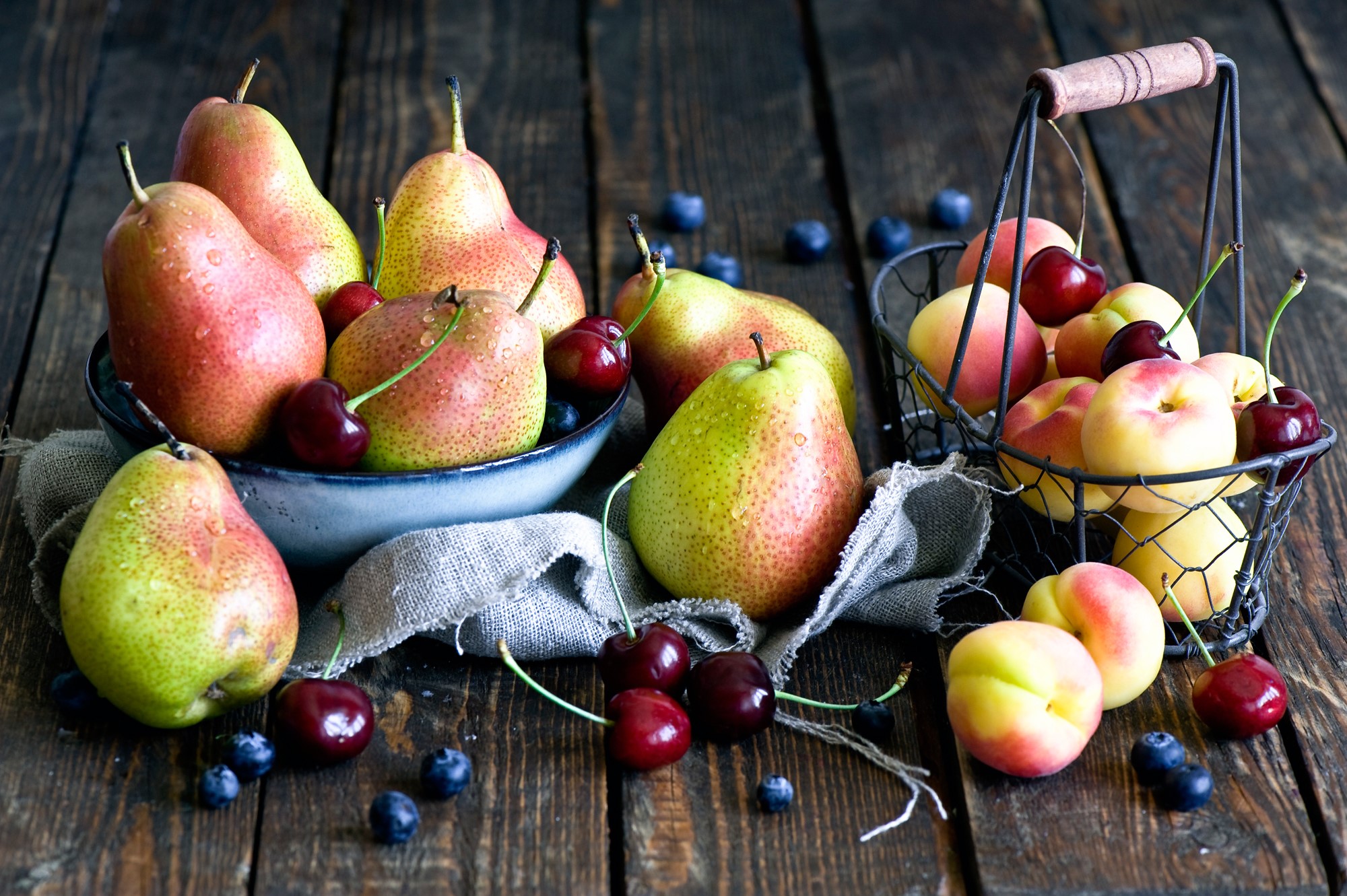 Still life of pears, peaches, cherries, and blueberries on wood HD Wallpaper